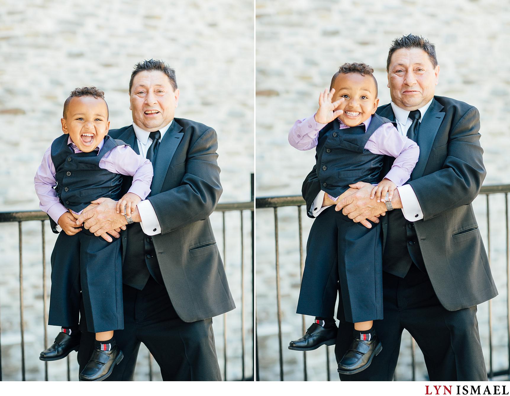 A cute toddler poses with his father on his wedding day.