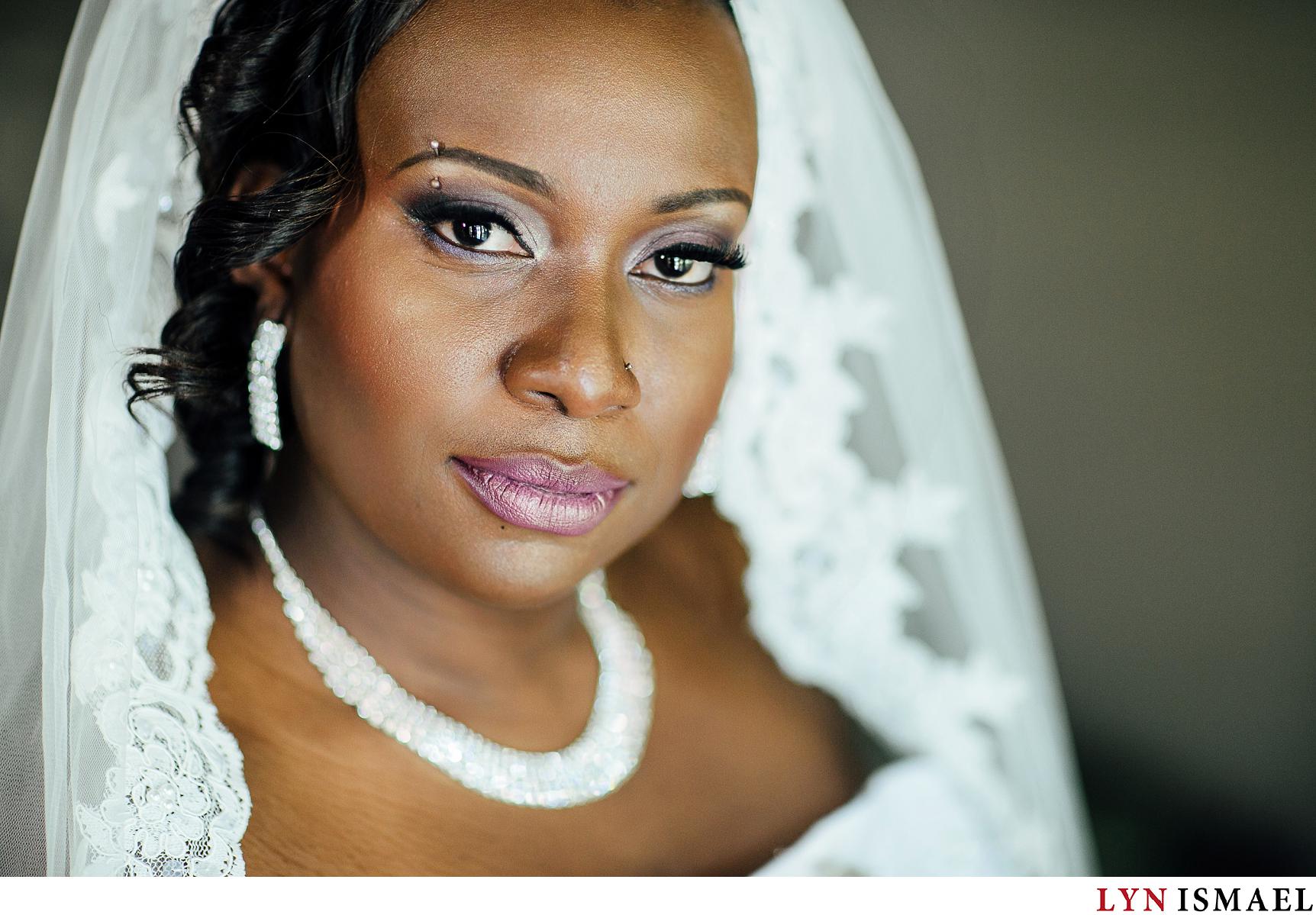 Portrait of a beautiful African-American bride where a makeup artist used purple eyeshadow and lipstick