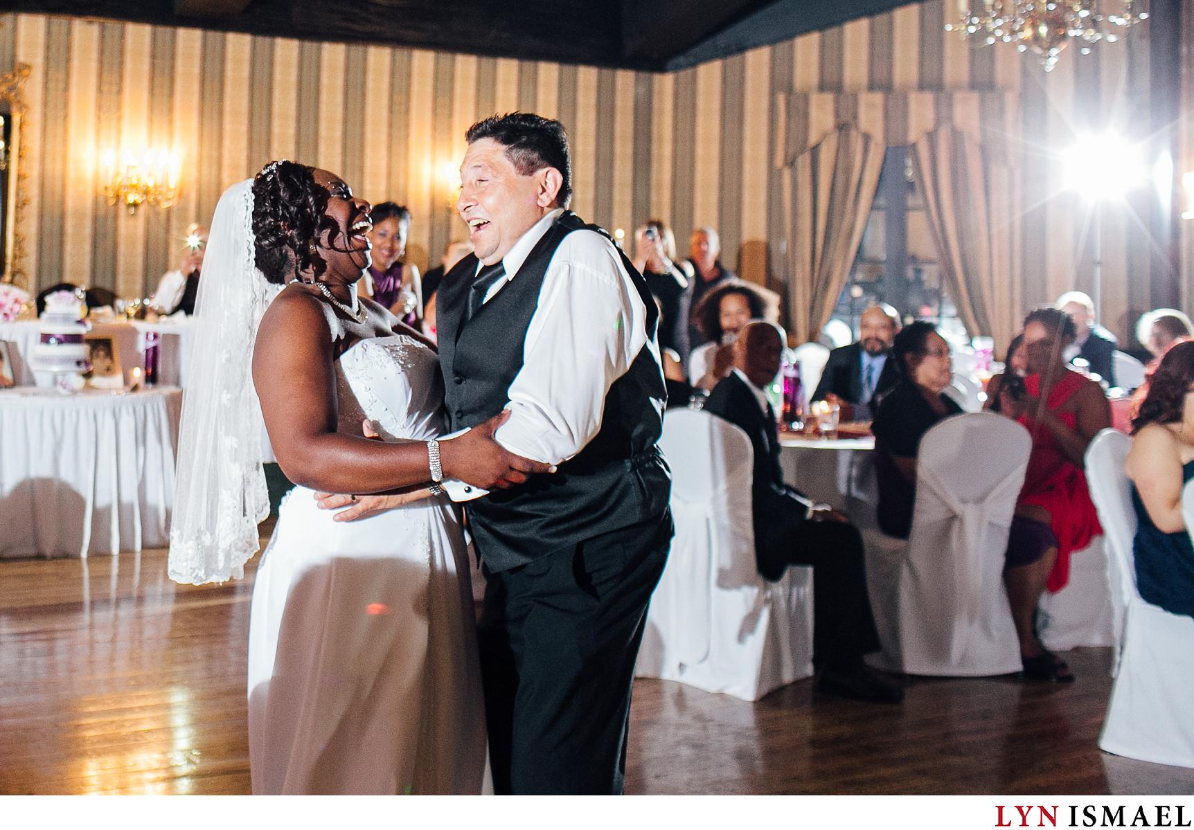 An African-American bride and an Italian-Canadian groom perform their first dance in front of their guests at their Old Mill Inn wedding reception.