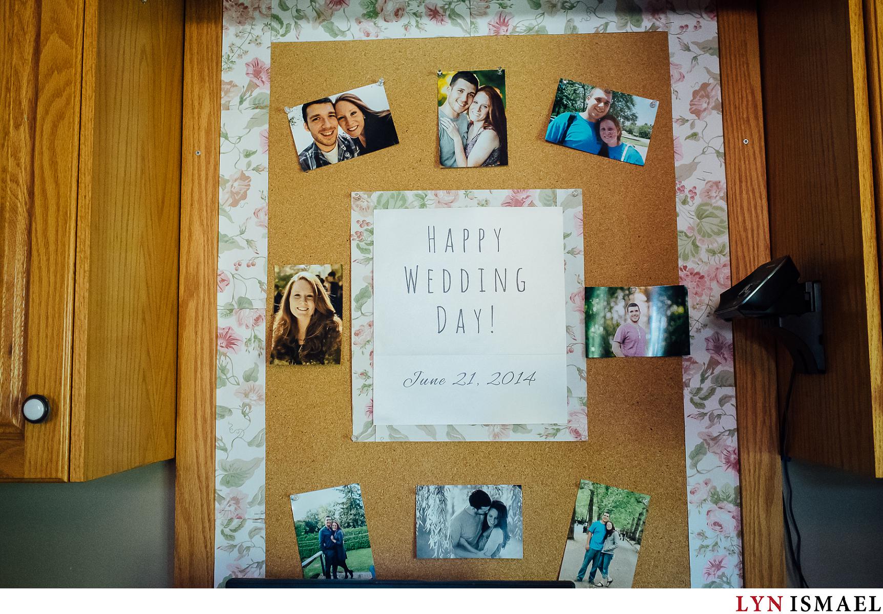 Engagement photos of the bride and groom displayed at the kitchen pin board