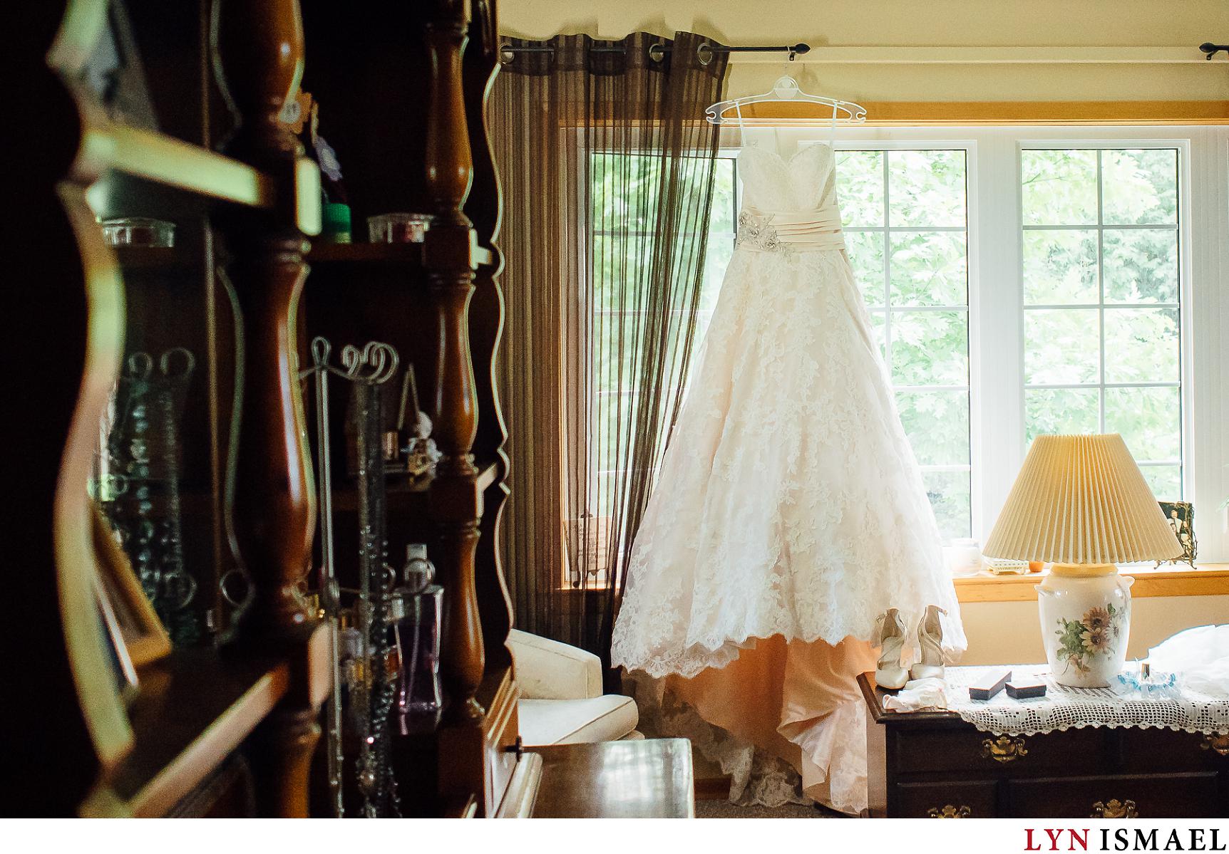Bride's dress hanging by the window