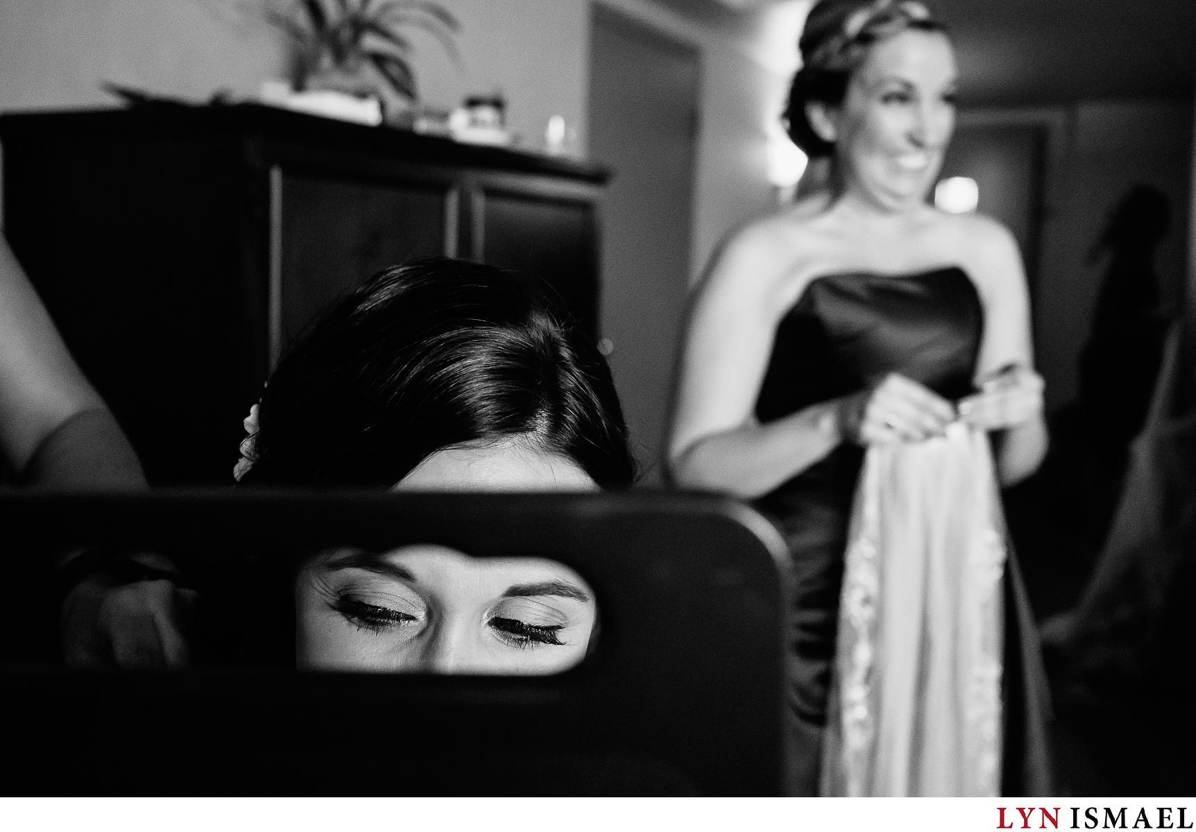 Bridesmaid looks excited to put the bride's veil on