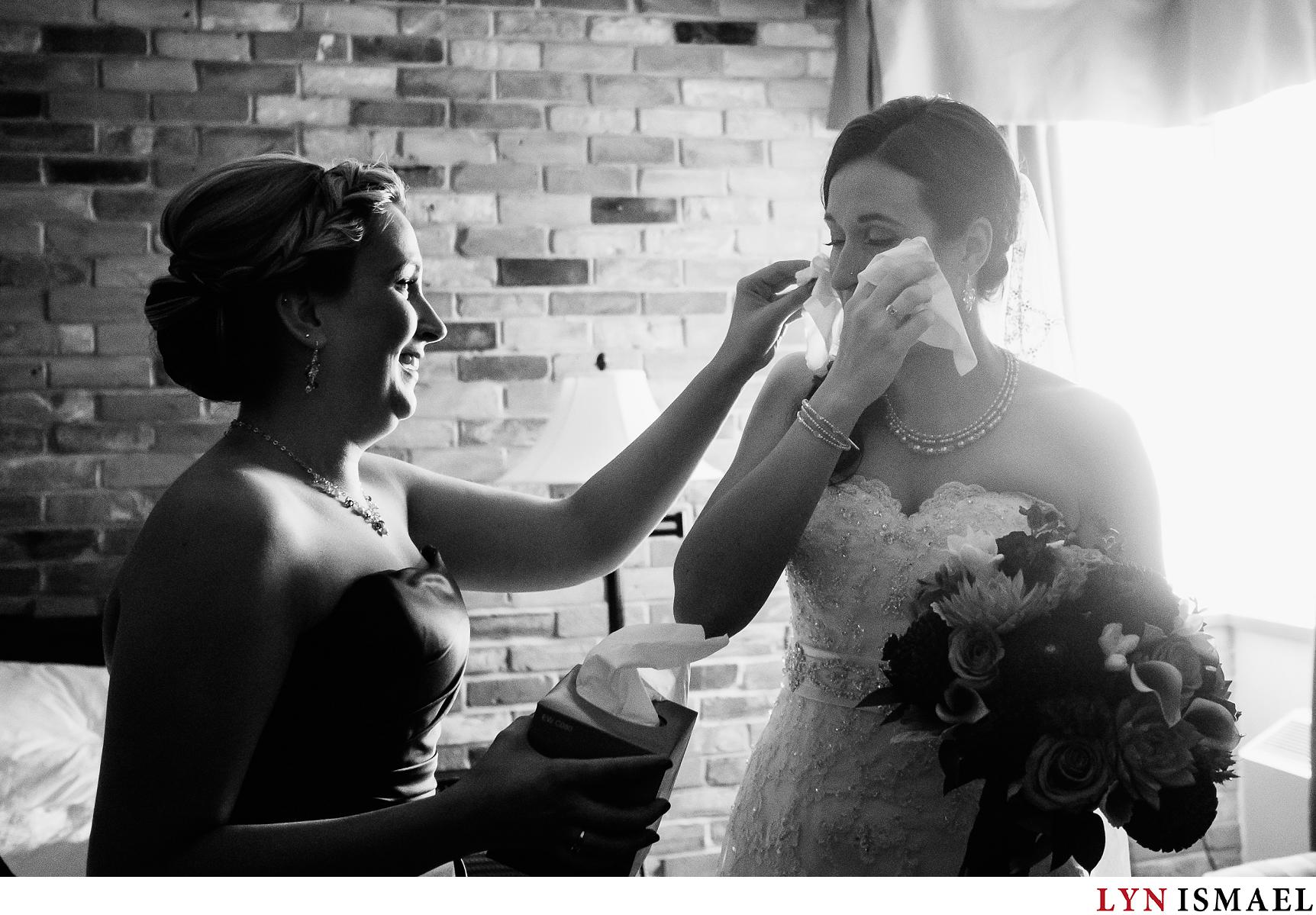Bride's sister give napkin for the bride to wipe her tears away