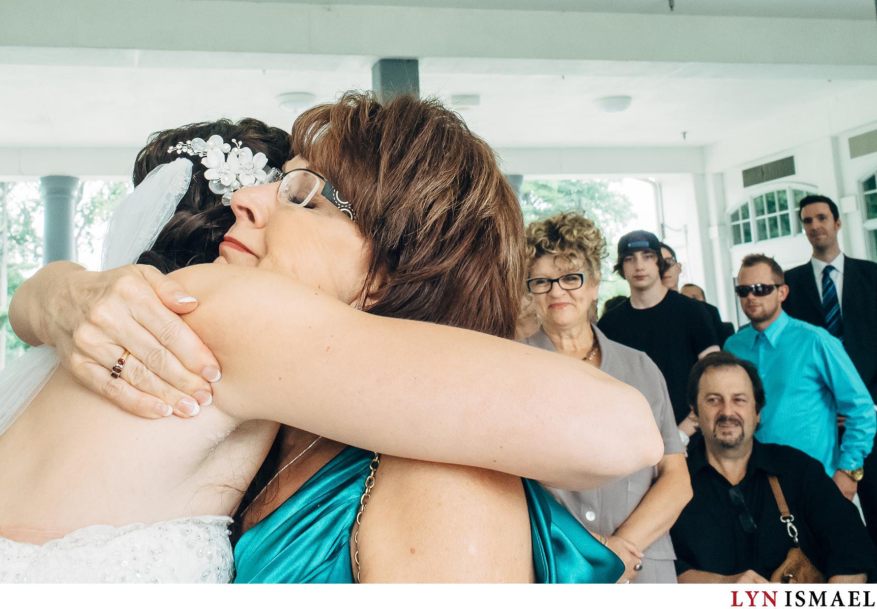Mother of the bride hugs her daughter as she gave her away