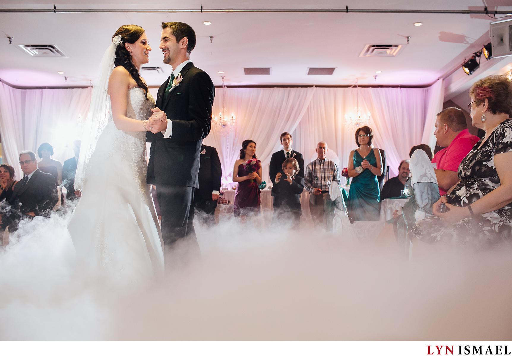 Bride and groom dance with fog in the ground