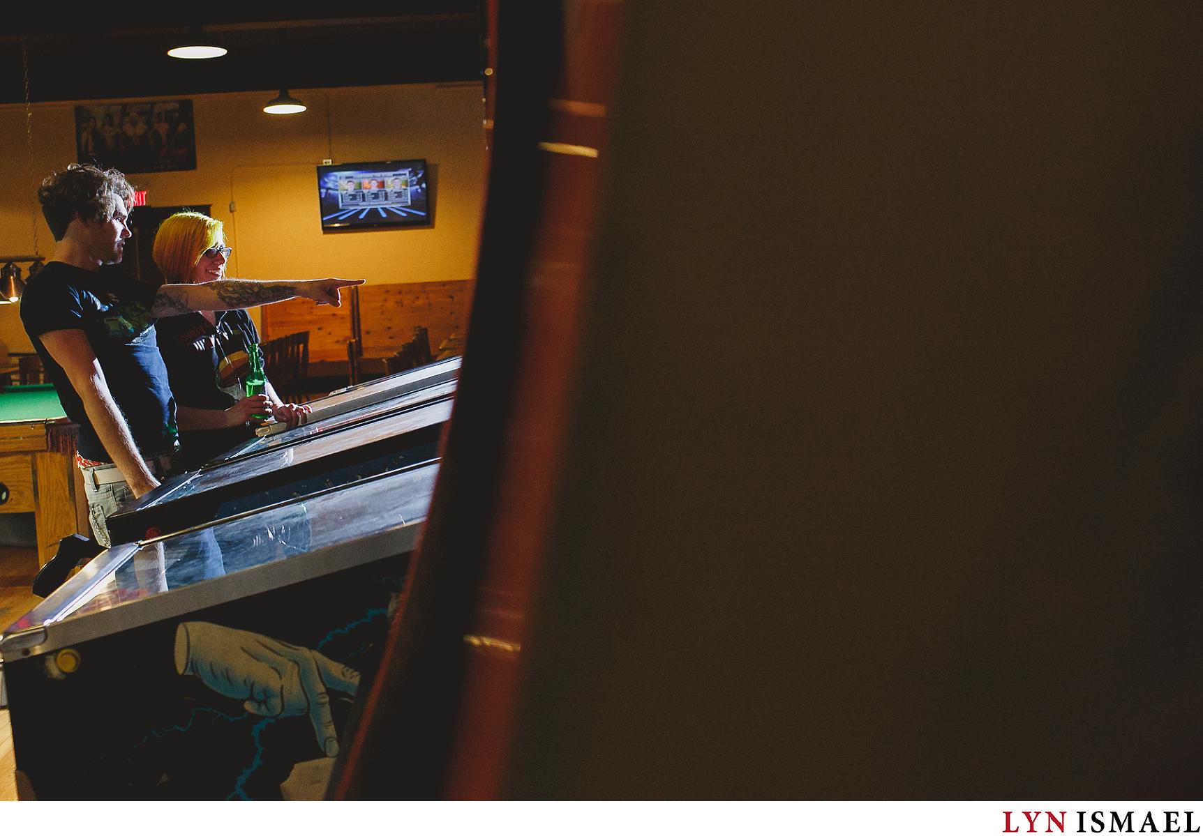 Wedding photographer Lyn Ismael photographs a couple re-enacting their first date by playing Pinball machines.