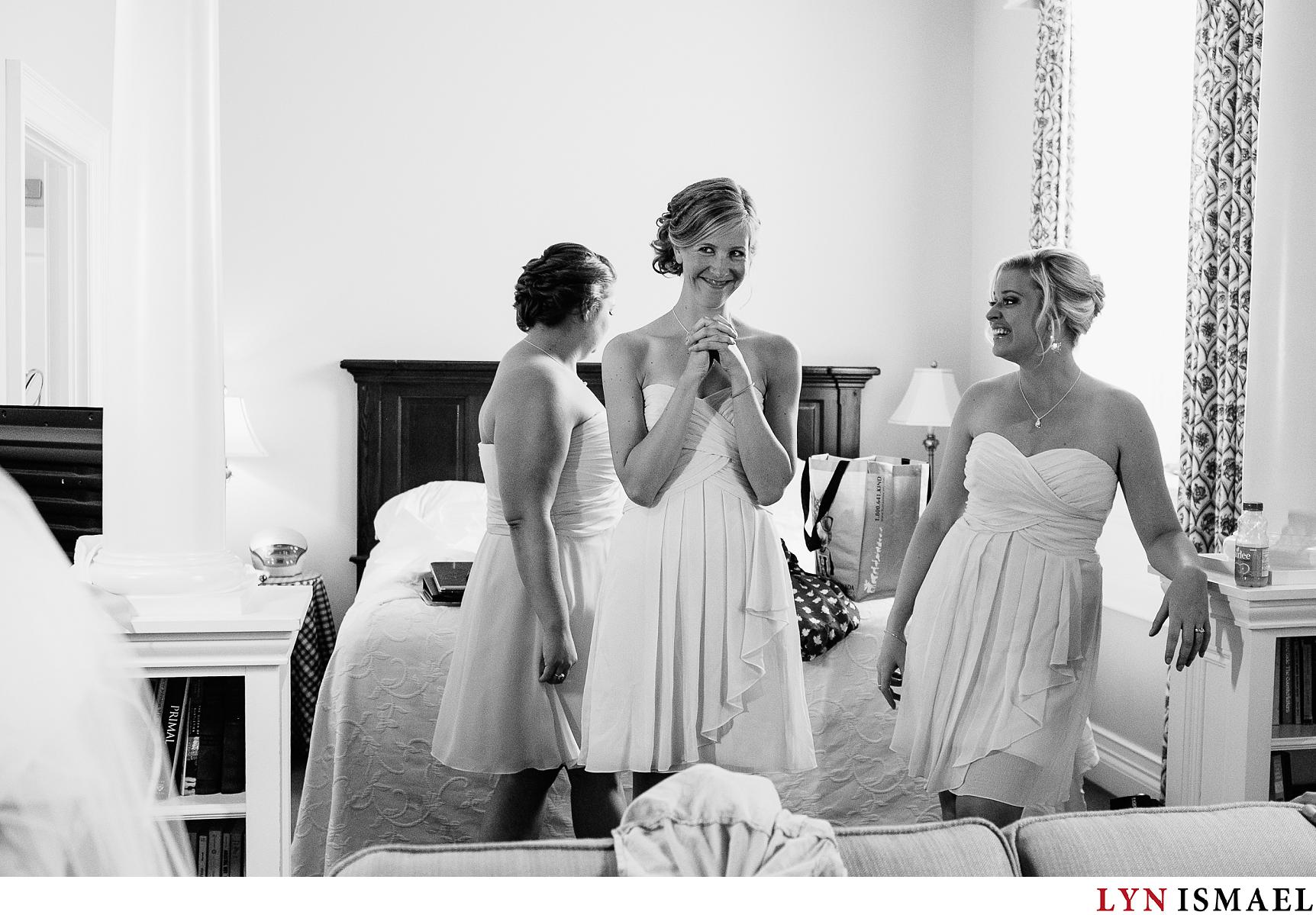Bridesmaids watch their friend transform into a bride.