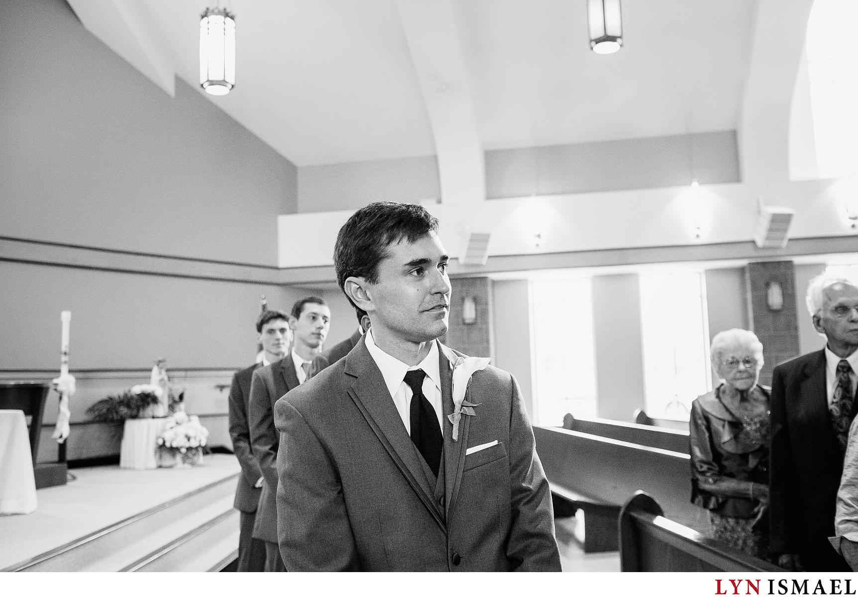 Groom watches his bride walk down the aisle.