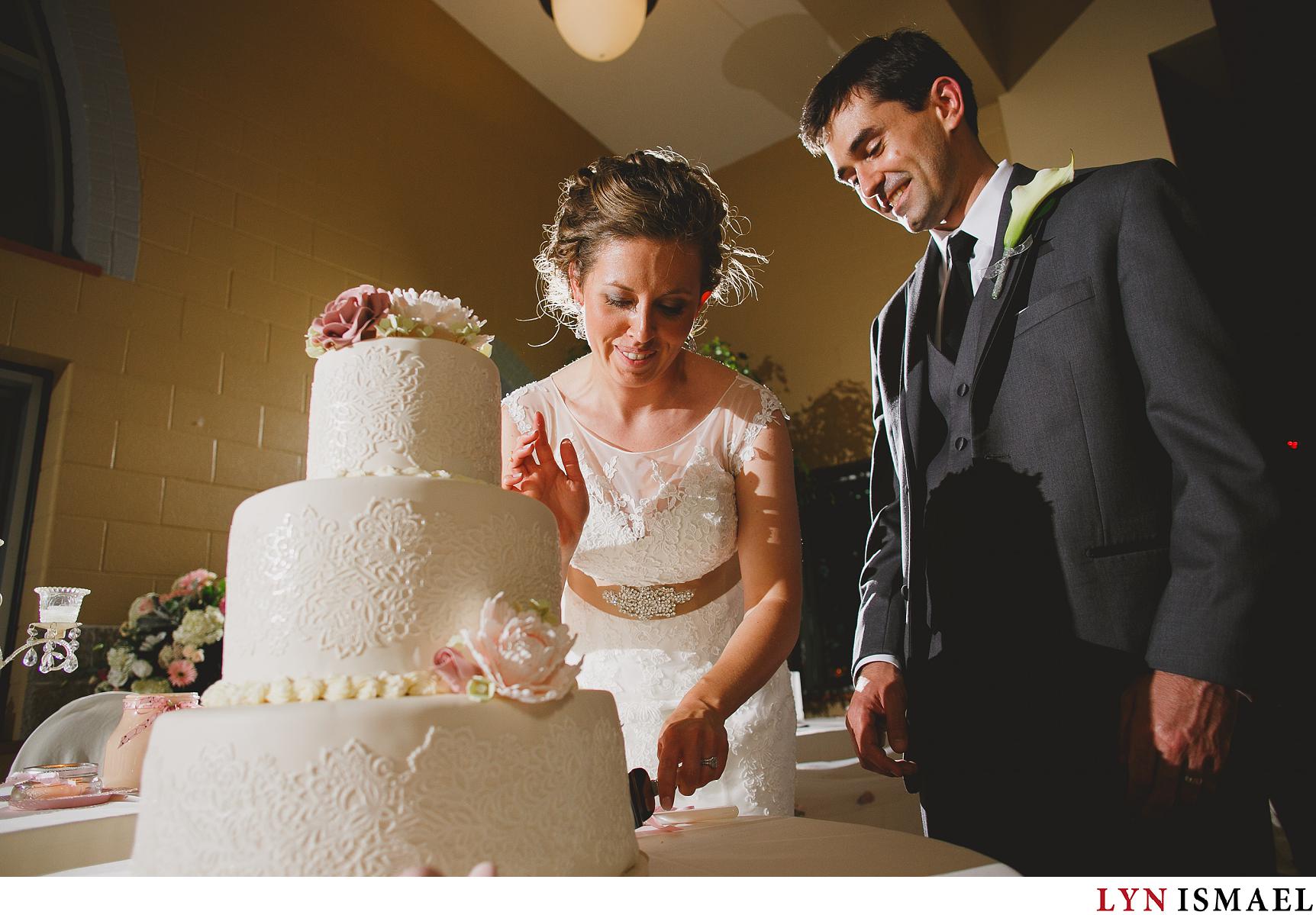 A bride and groom cuts their cake at their Stoney Creek wedding reception