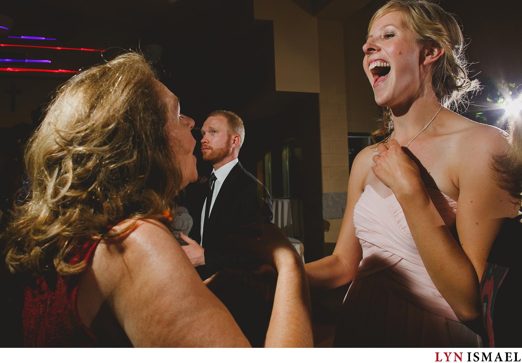 Bridesmaid and mother of the groom having a great time dancing.