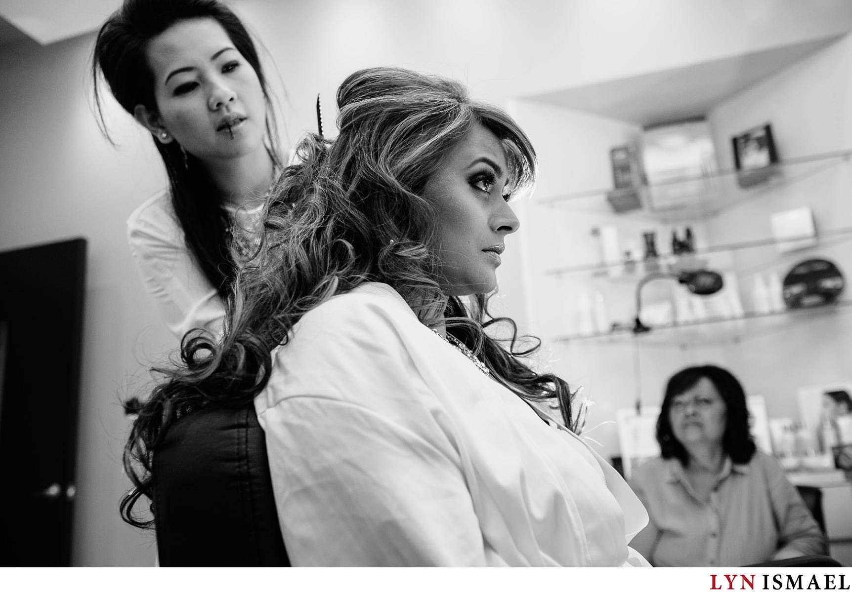 a hairstylist teases the bride's hair