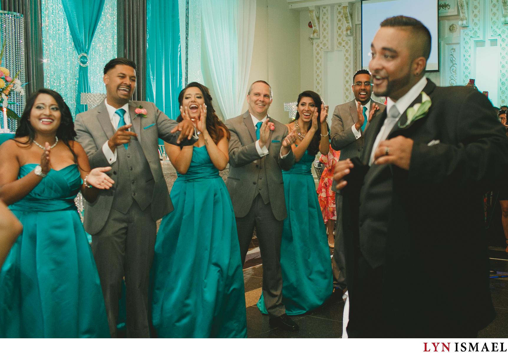 The wedding party cheers on as the bride and groom enters Paradise Banquet Hall for their wedding reception