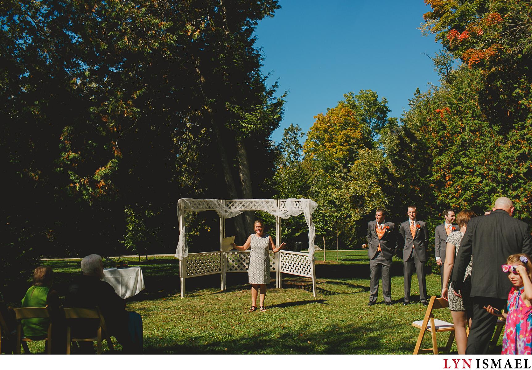 The officiant gets everyone ready at an outdoor ceremony in Victoria Park in Elora, Ontario.