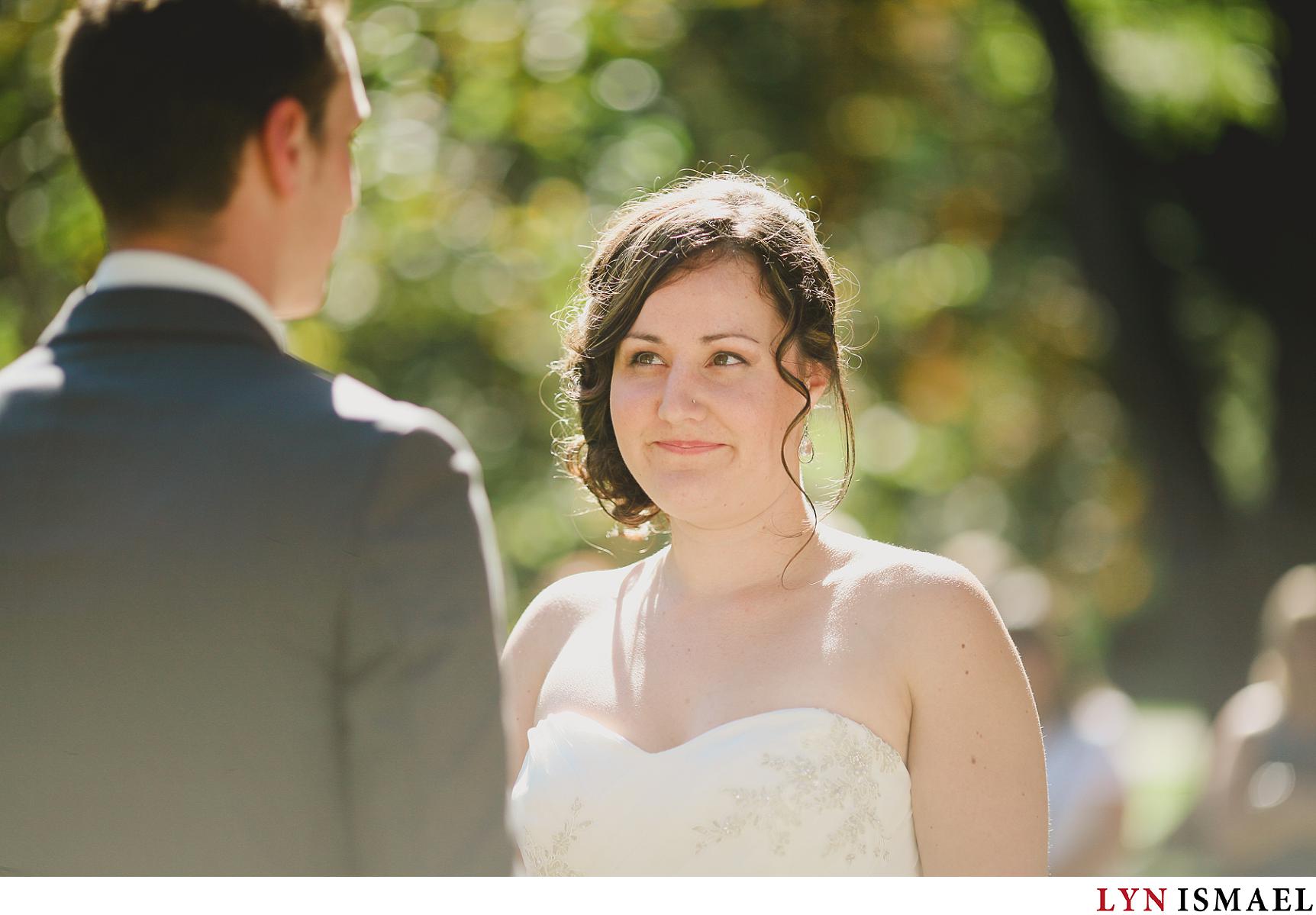 A bride looks at her groom as they exchanged vows at an outdoor wedding ceremony in