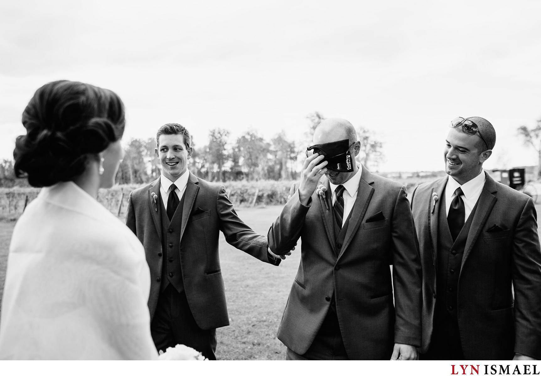 Groomsmen deliver the groom to his bride blindfolded.