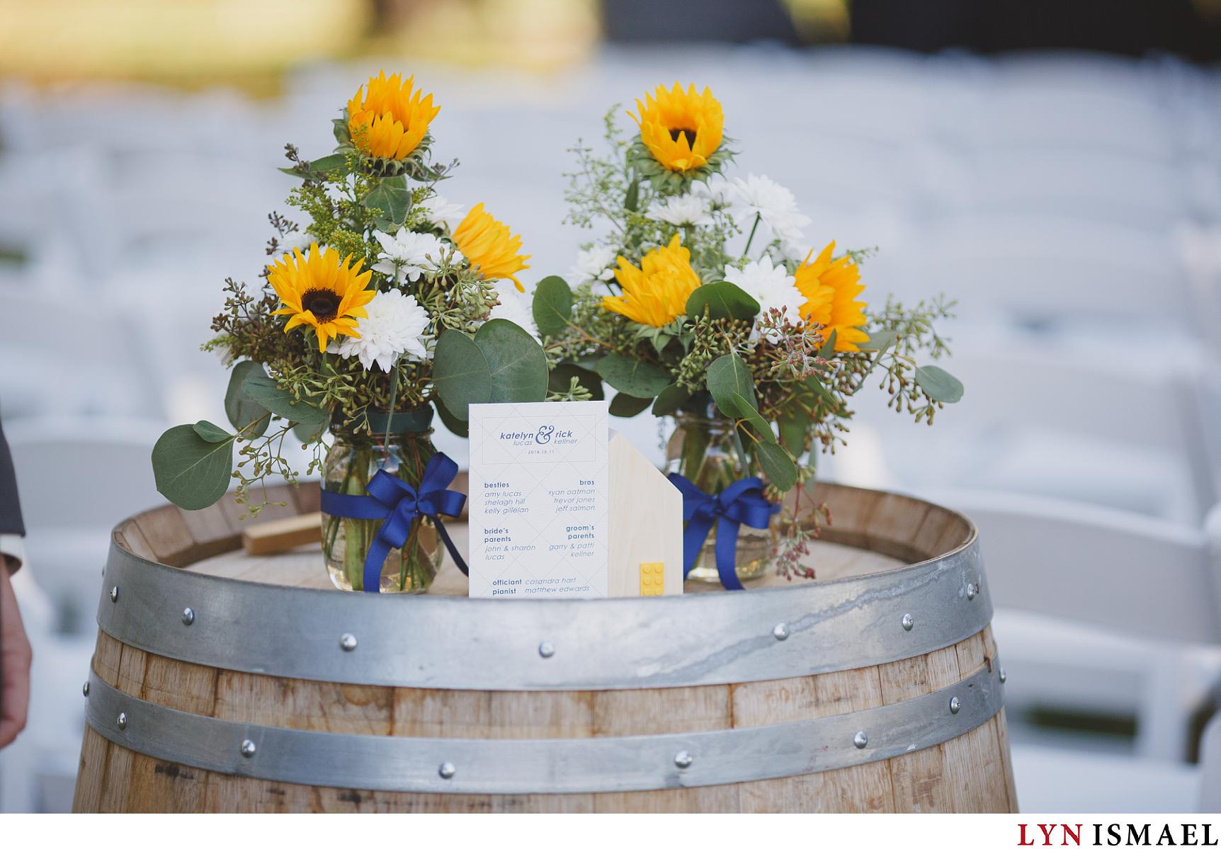 Yello sunflowers in mason jars decorated with royal blue ribbons.
