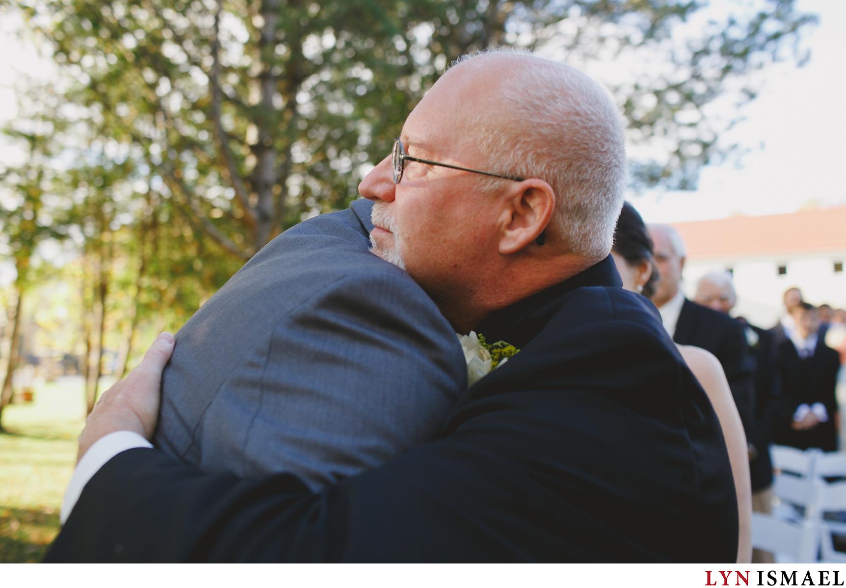 Bride's father hugs the groom