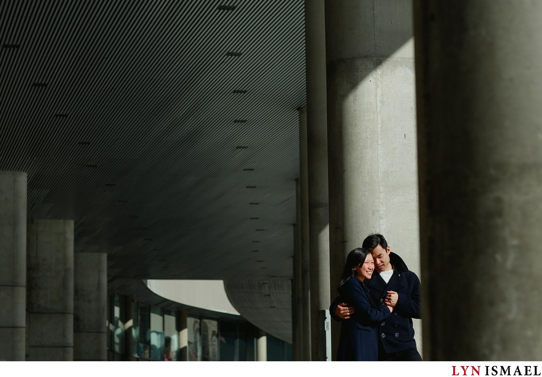 A wedding photographer in Toronto plays with light and shadow at an Asian couple's engagement session at Nathan Phillips Square.