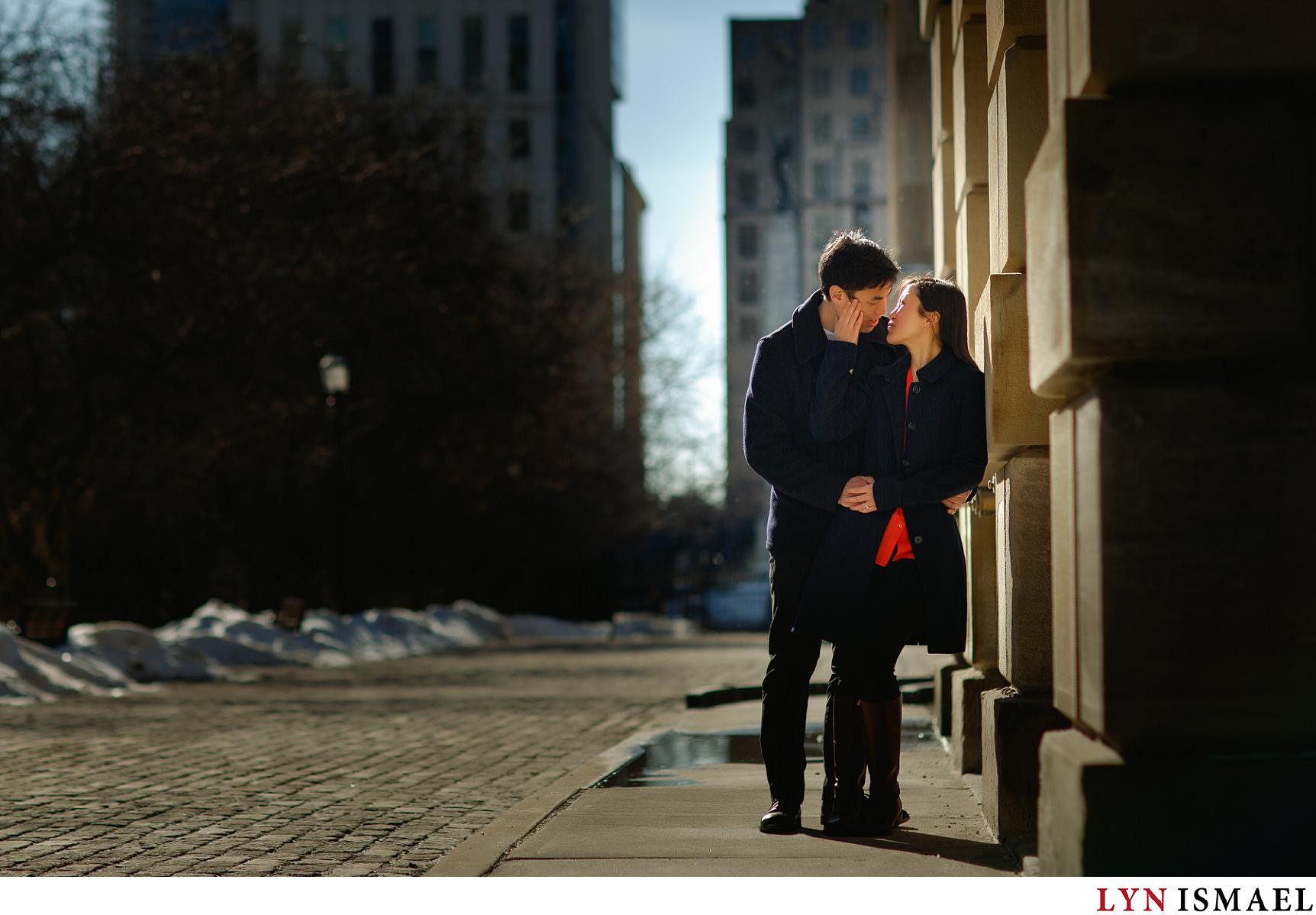 Dramatically lit engagement portrait of Lelia and Chris in front of Osgood Hall in Toronto, Ontario.