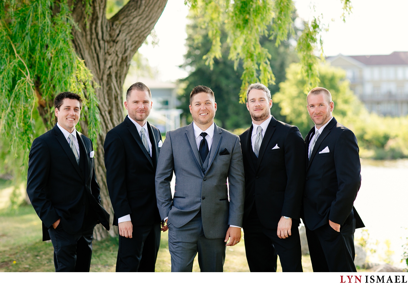 portrait of a groom and his groomsmen wearing summer suiting