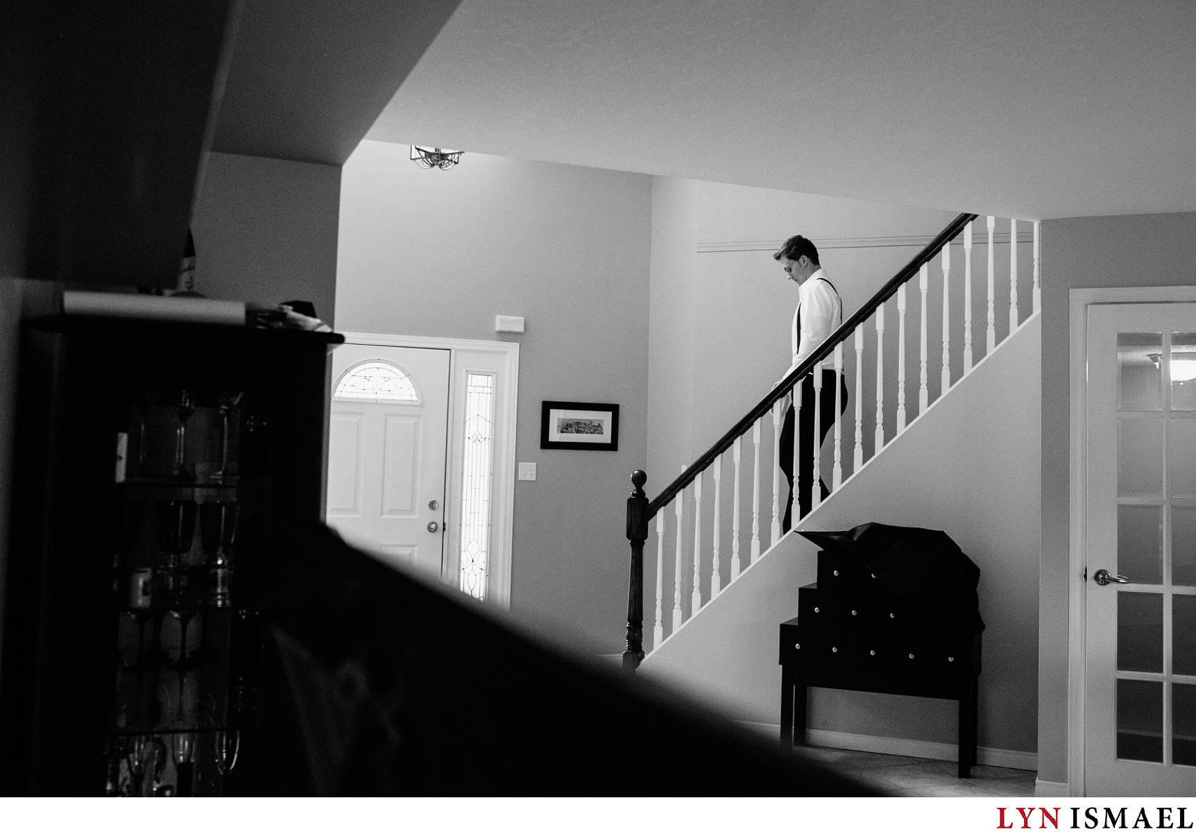 Groom climbs down the staircase from the second level of their home.