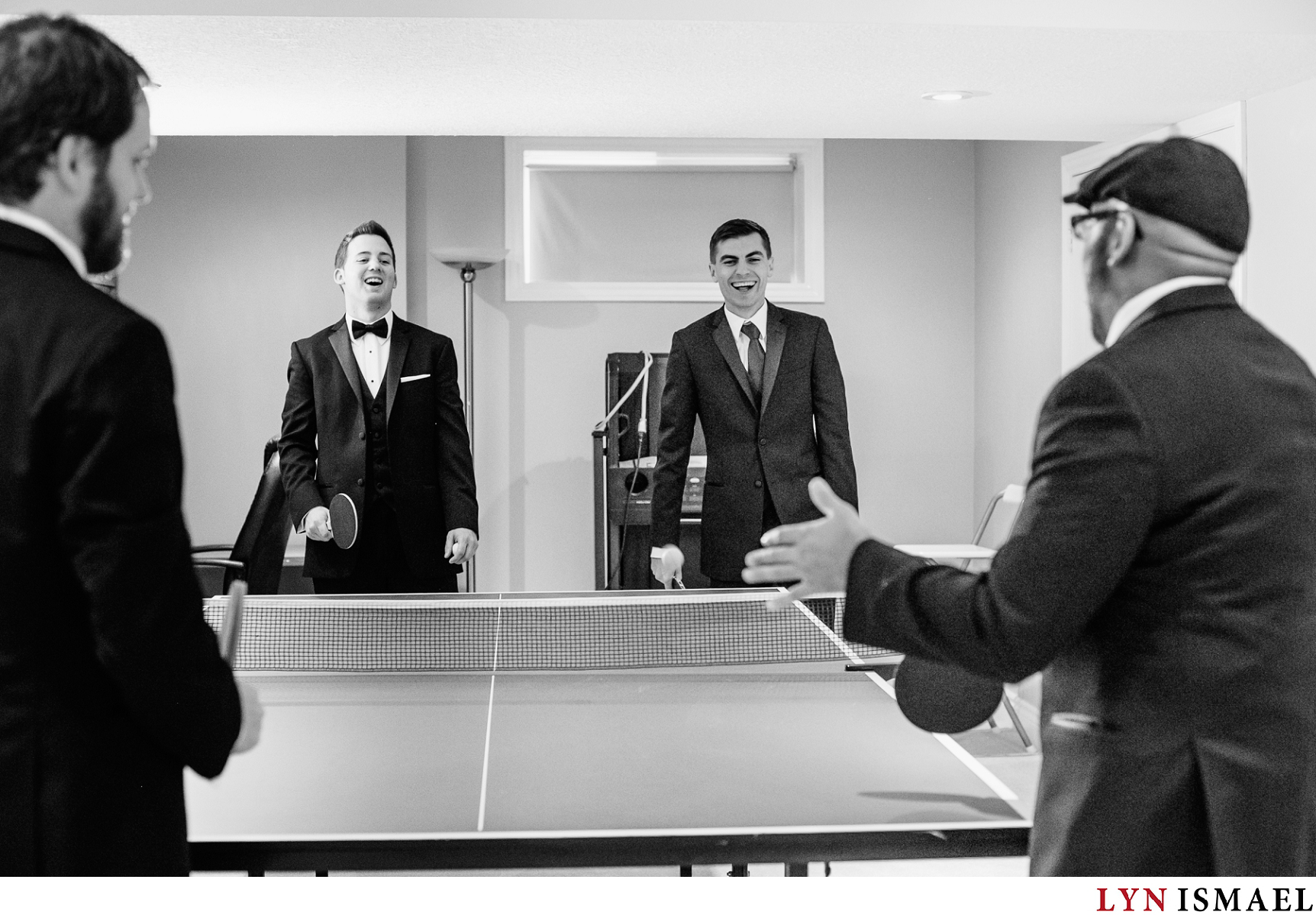Groom and groomsmen playing ping pong before the wedding ceremony