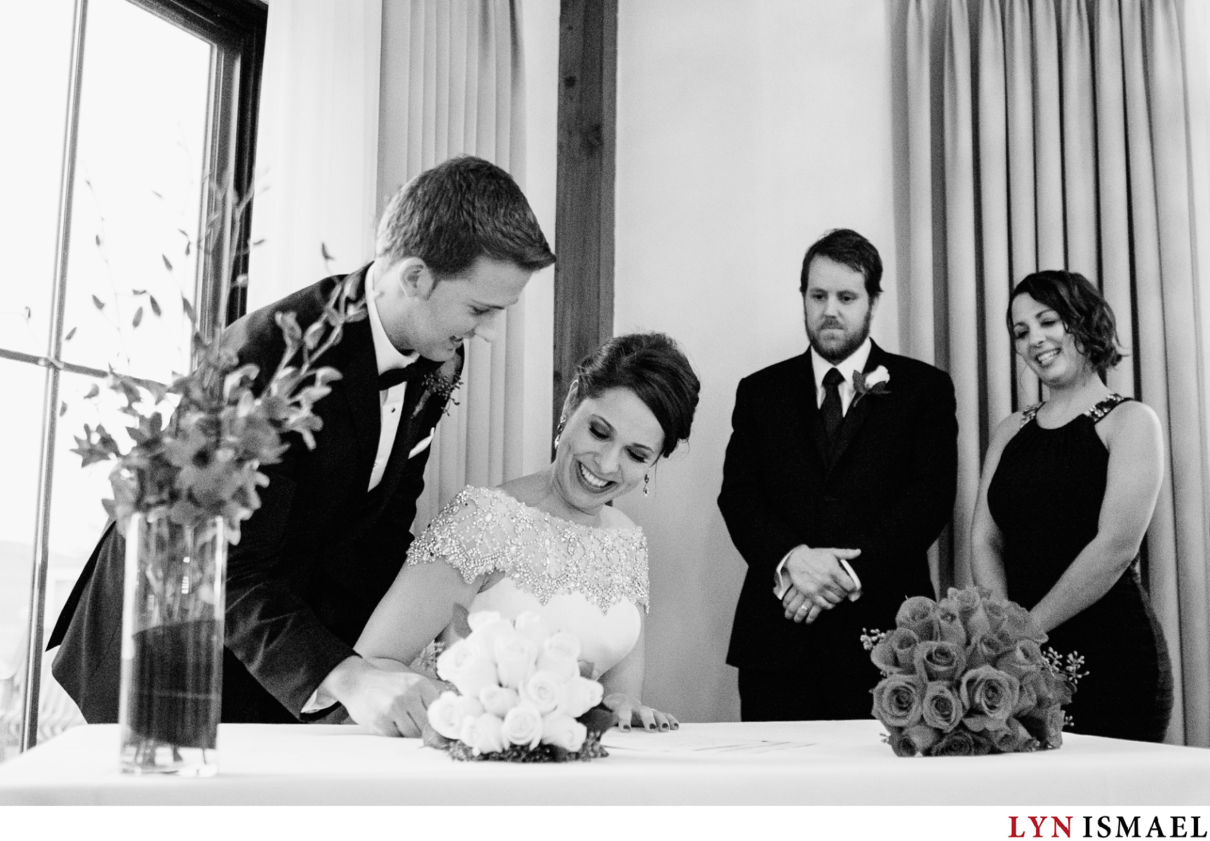 The bride and groom signs their wedding contract while their witnesses watch on.
