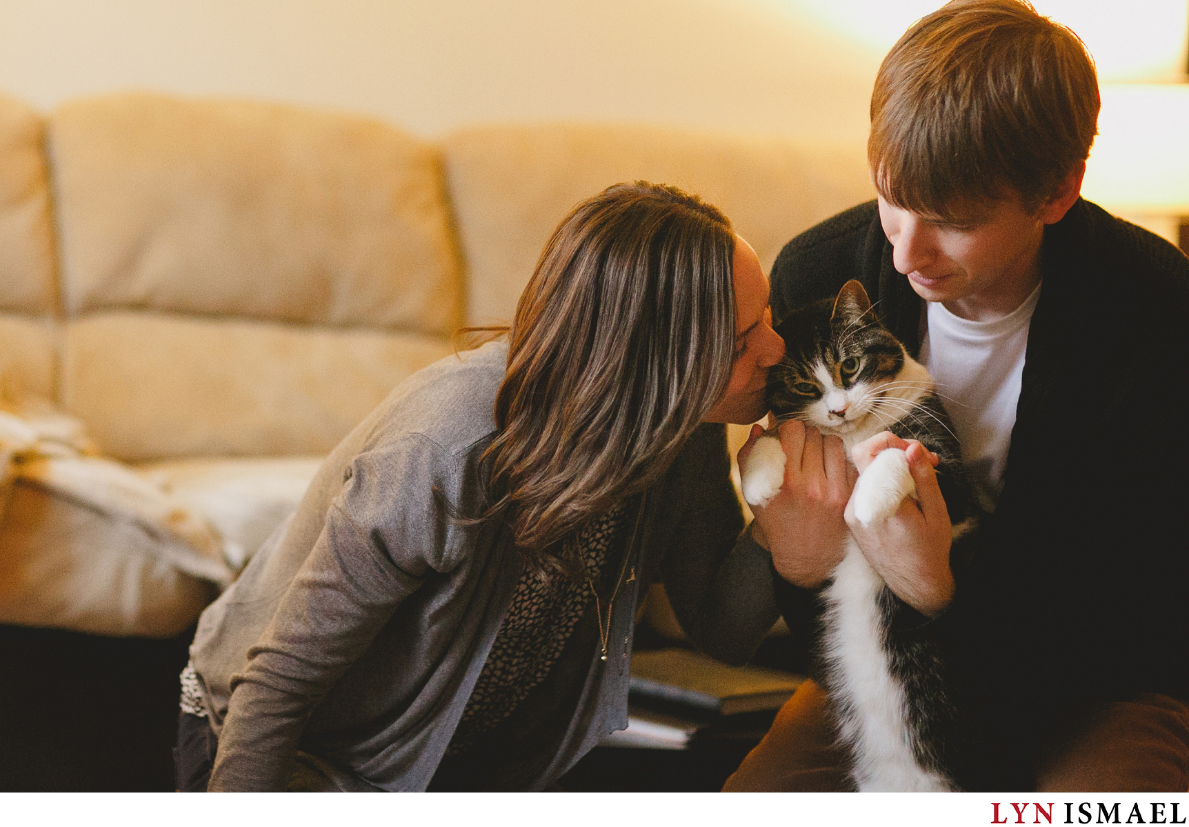 An engaged couple plays with their cats during their engagement session