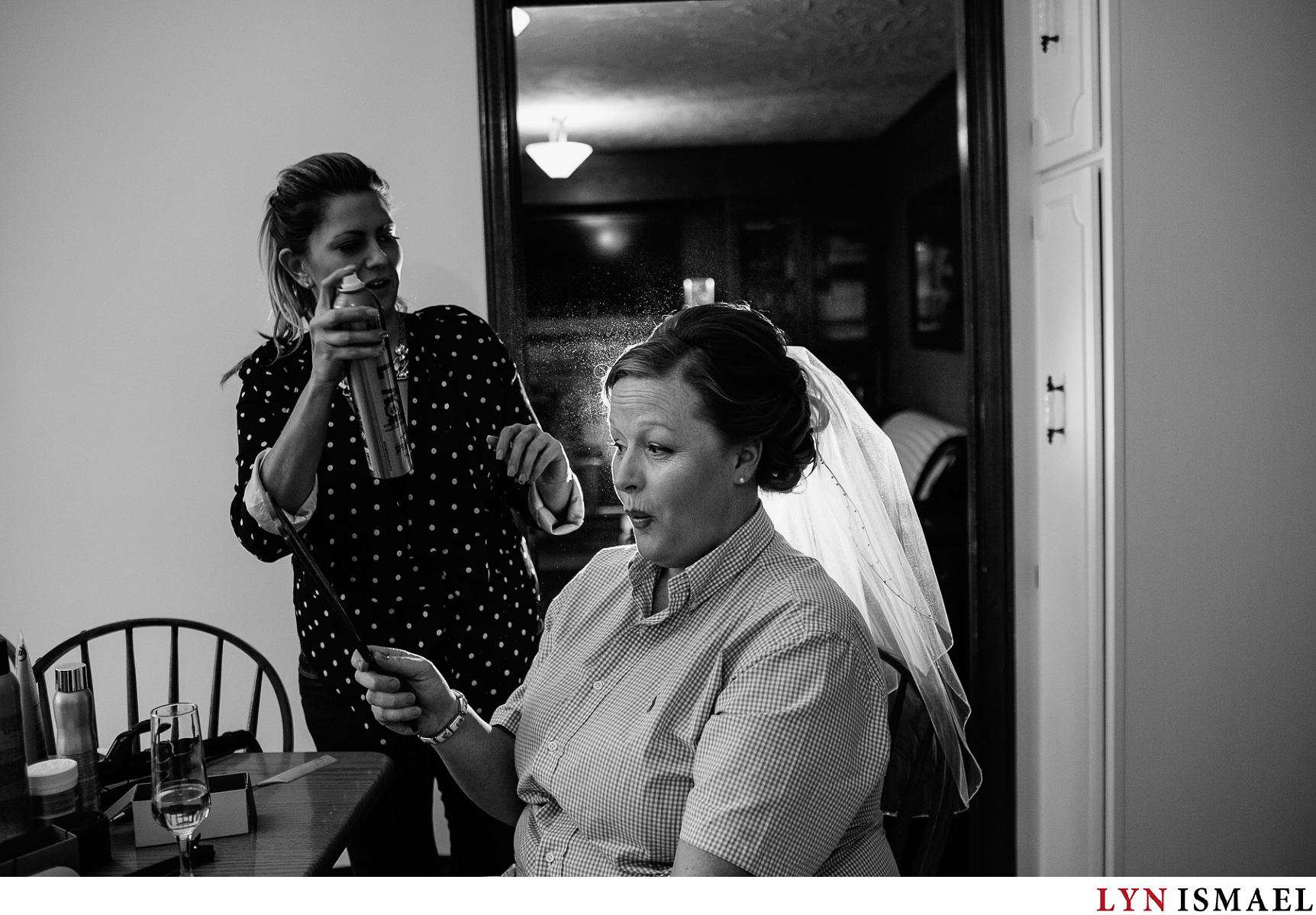 Bride get's her hair done at home before her wedding.
