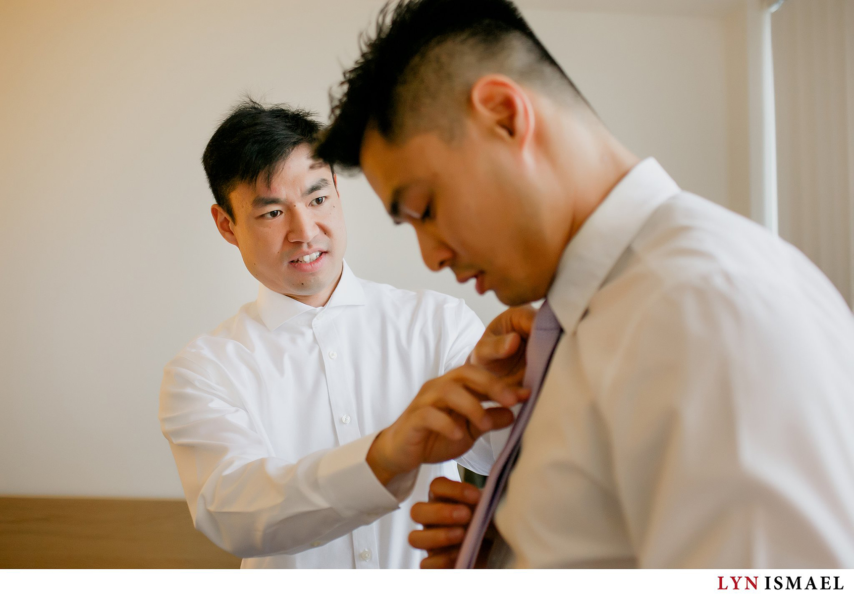 Groom helps his brother with his tie as they got ready