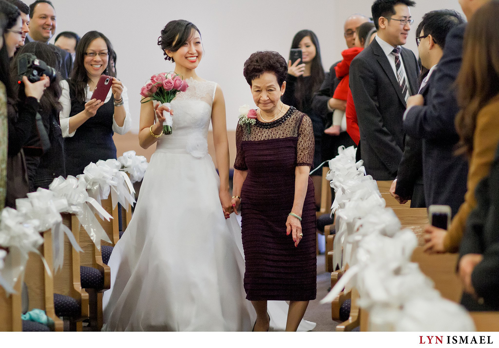 Bride walks down the isle with her grandmother.