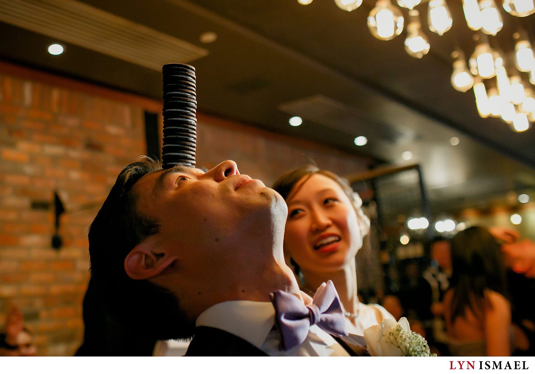 Groom balances a stack of Oreo cookies at his wedding reception at Reds Wine Tavern in Toronto, Ontario.