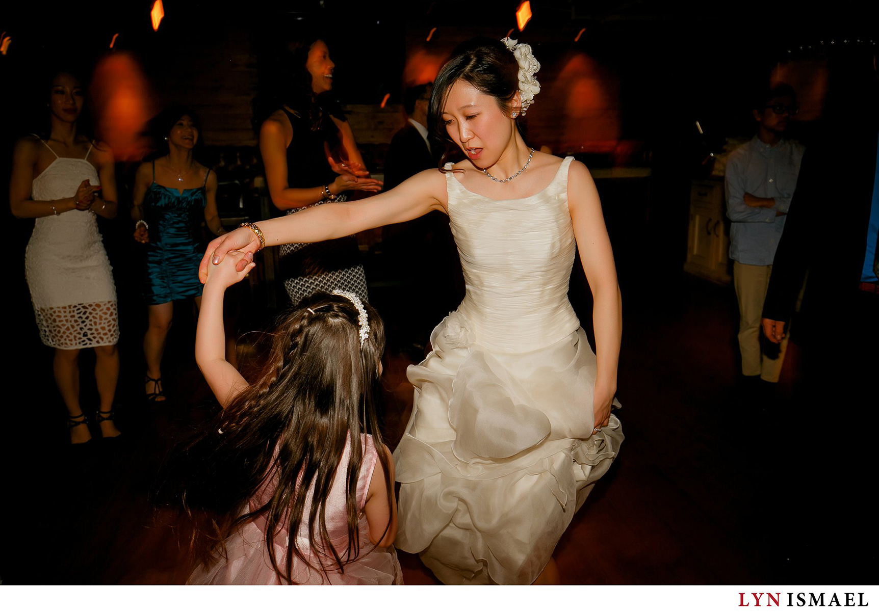 Bride dancing with a little girl at Reds Wine Tavern in Toronto, Ontario.