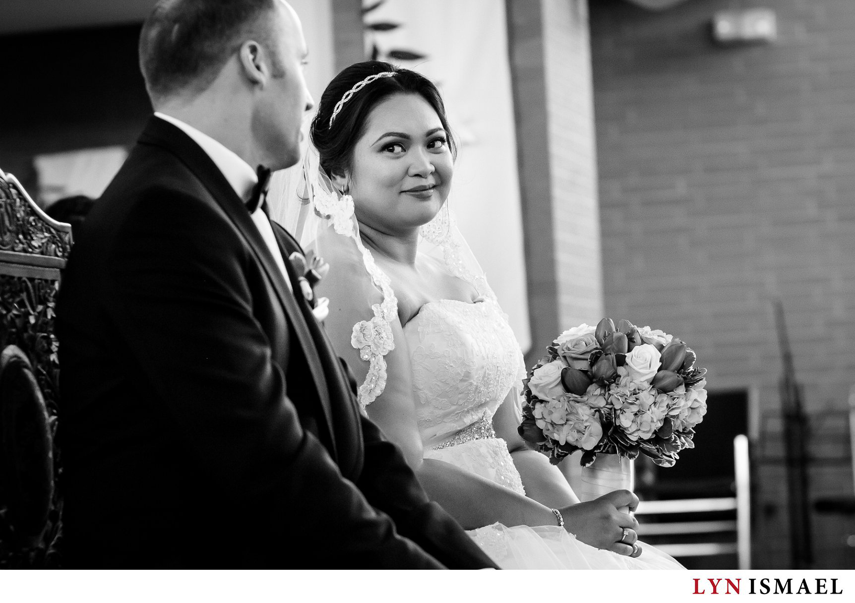Bride and groom exchange glances at their wedding ceremony at St Francis Xavier Church.