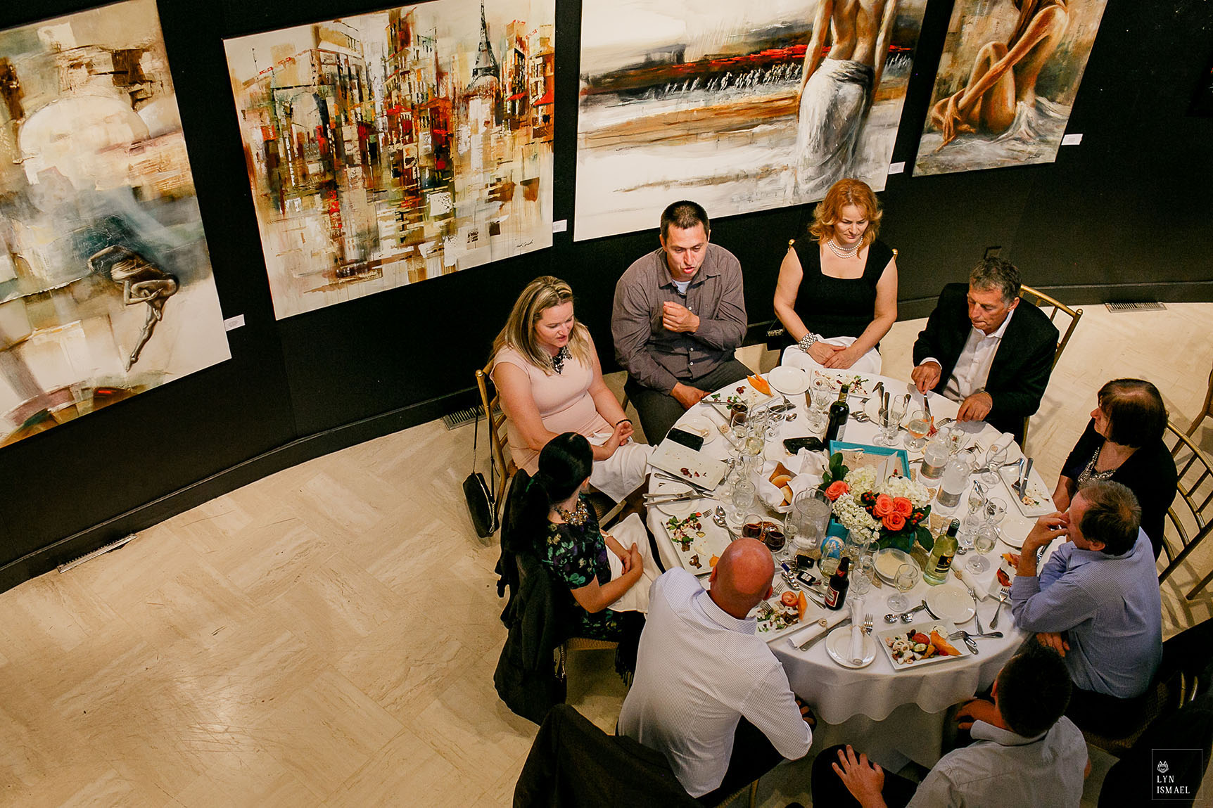 Guests eating dinner surrounded by art works at the Joseph D Carrier art gallery