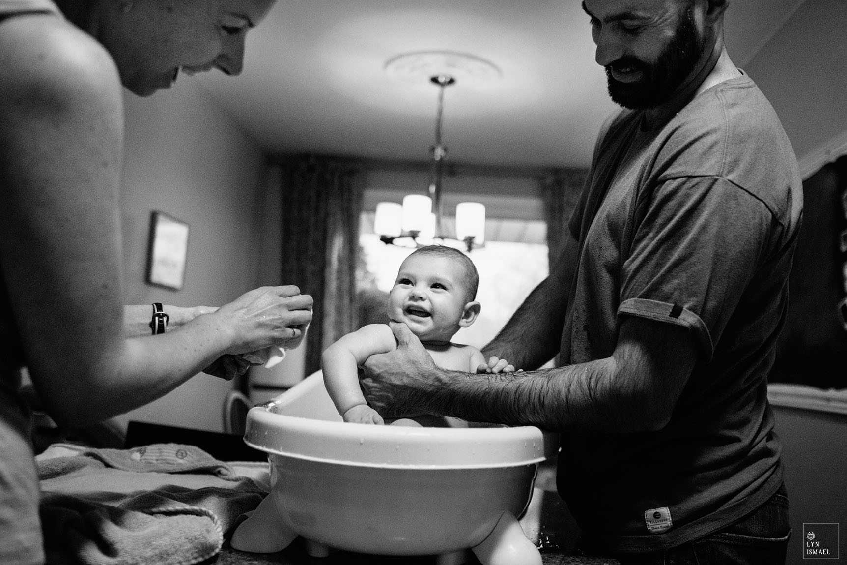Kitchener family documentary photographer photographs a young family at bath time.