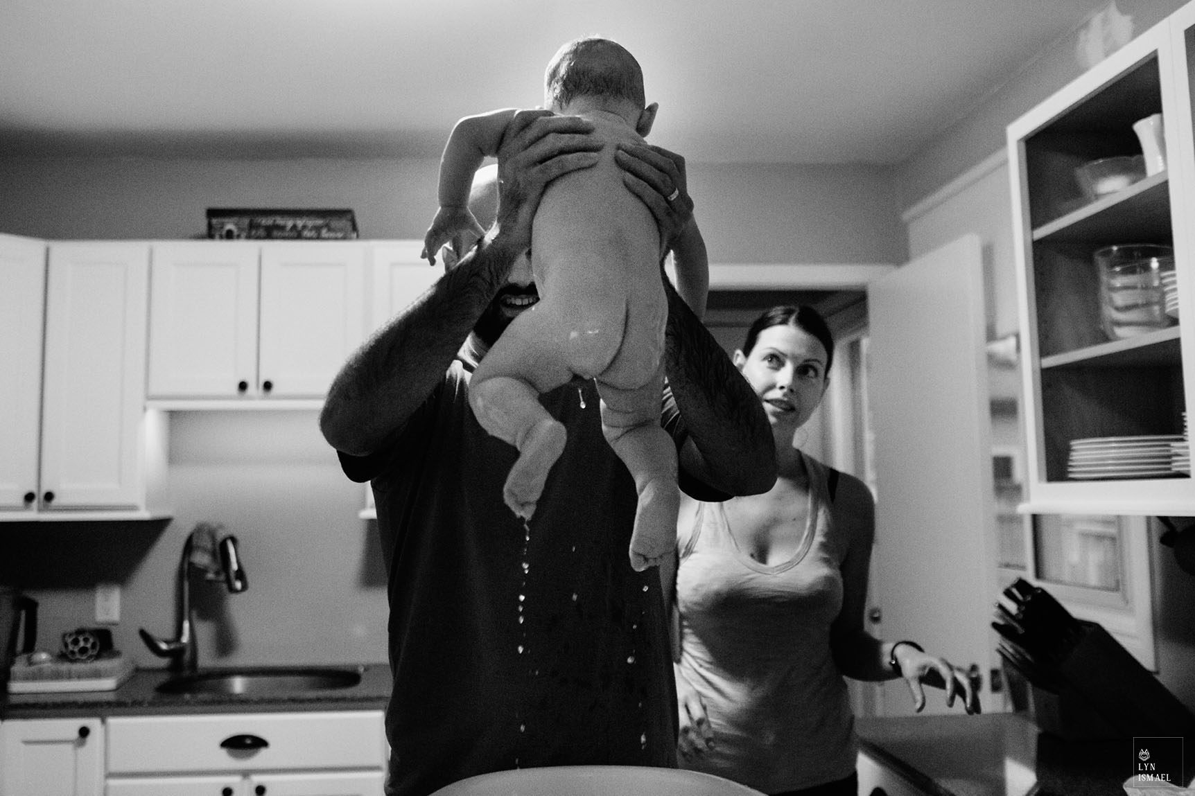 A baby is taken out of his bath as photographed by Kitchener family documentary photographer