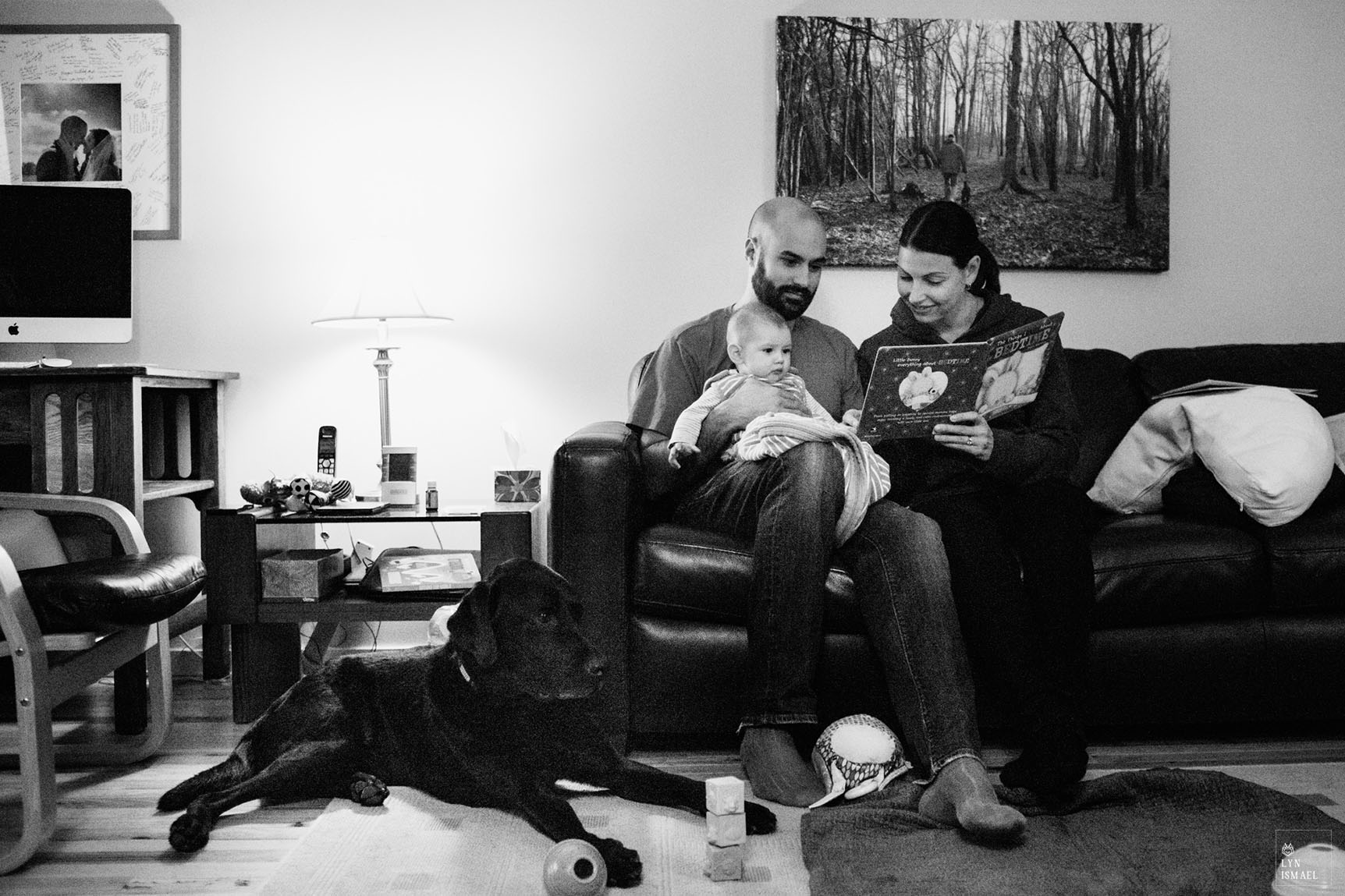 Kitchener family documentary photographer captures a new parents reading a book to their newborn son