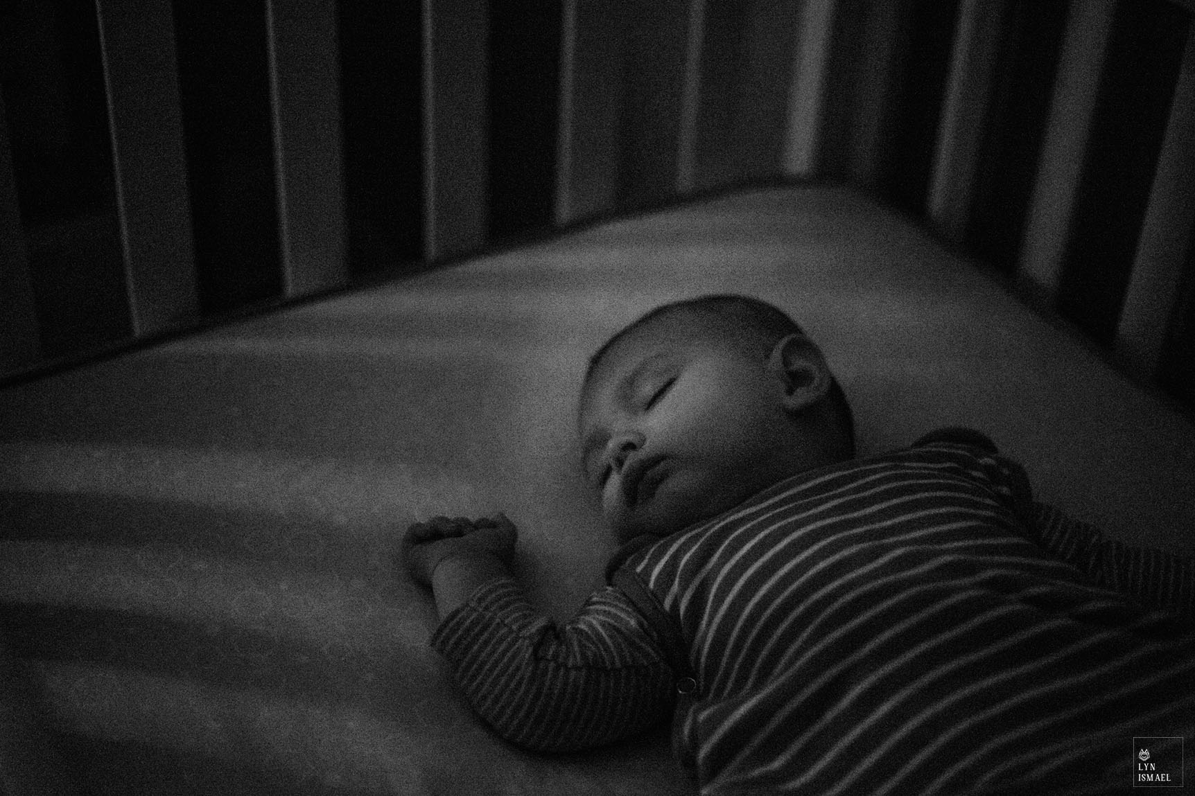 newborn sleeps in his crib as photographed by Kitchener family documentary photographer.