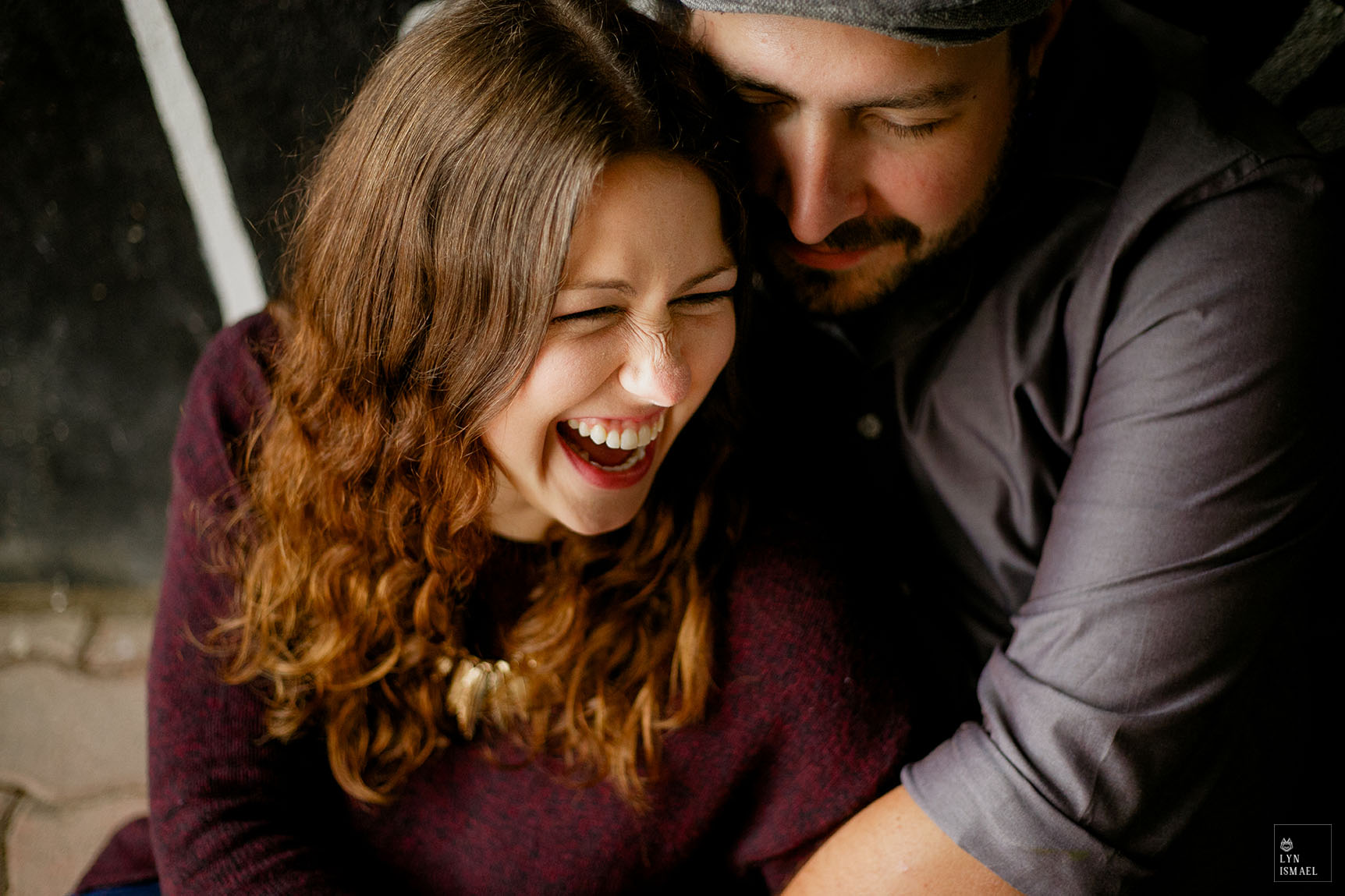A woman laughs at her fiance's joke during their Stratford engagement session.