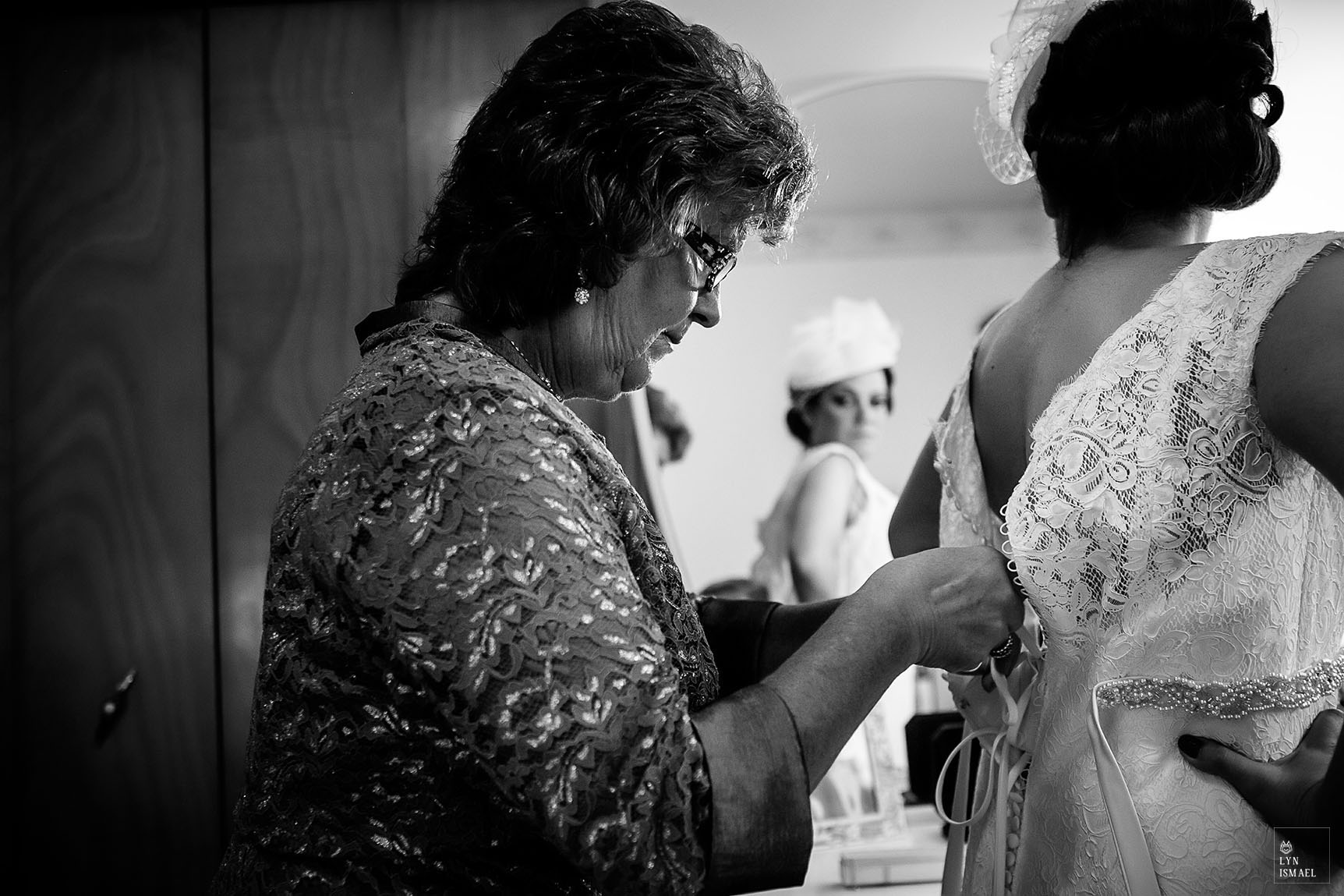 Bride's mother laces the back of her daughter's dress