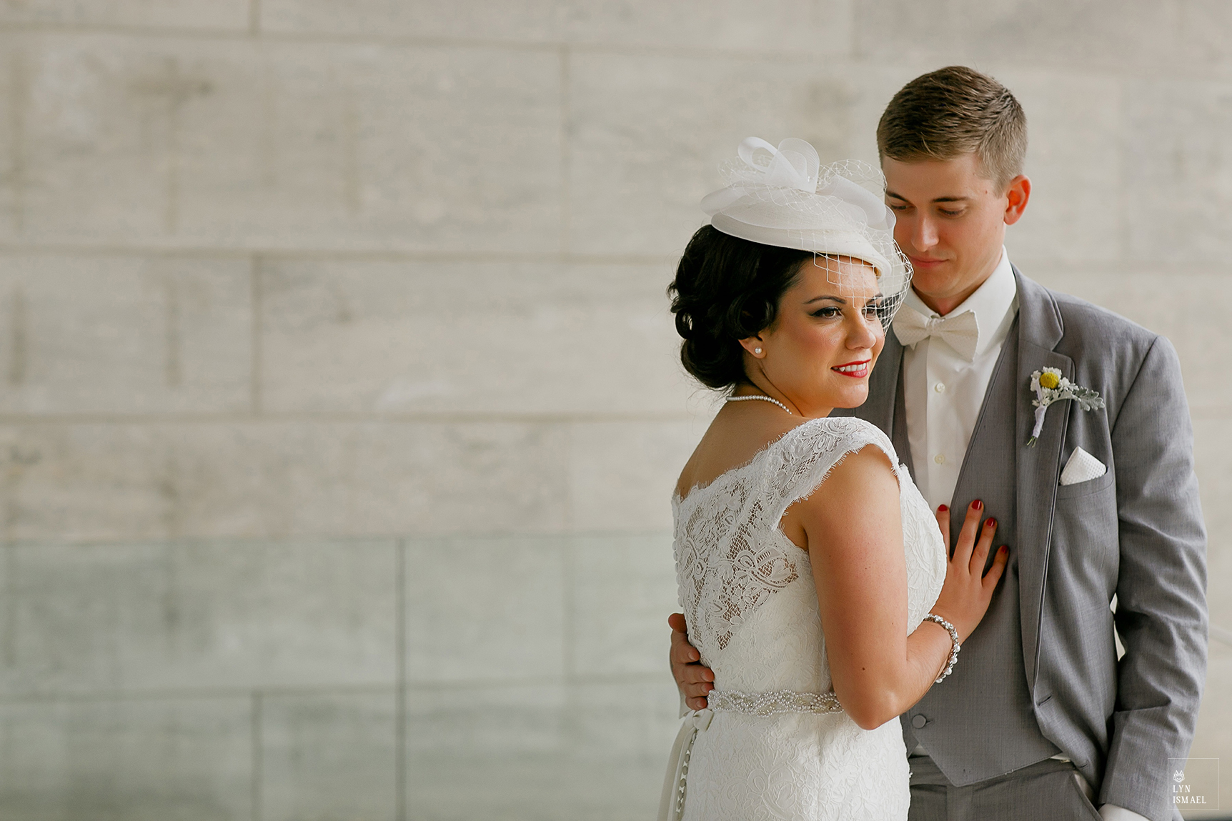Beautiful bride wearing a vintage headdress poses with her groom