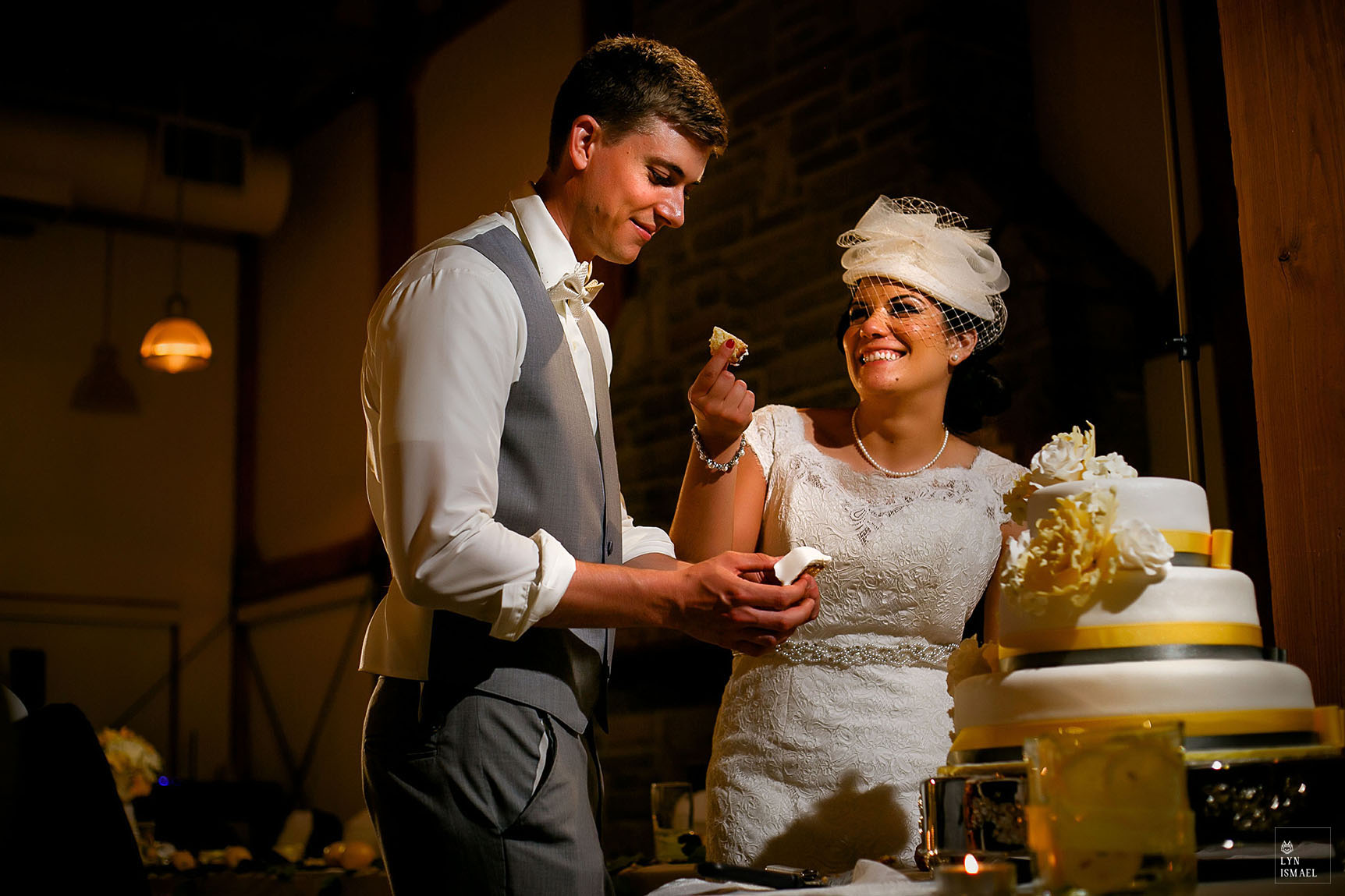 Bride and groom cut their cake at their wedding reception inside Grey Silo in Waterloo, Ontario