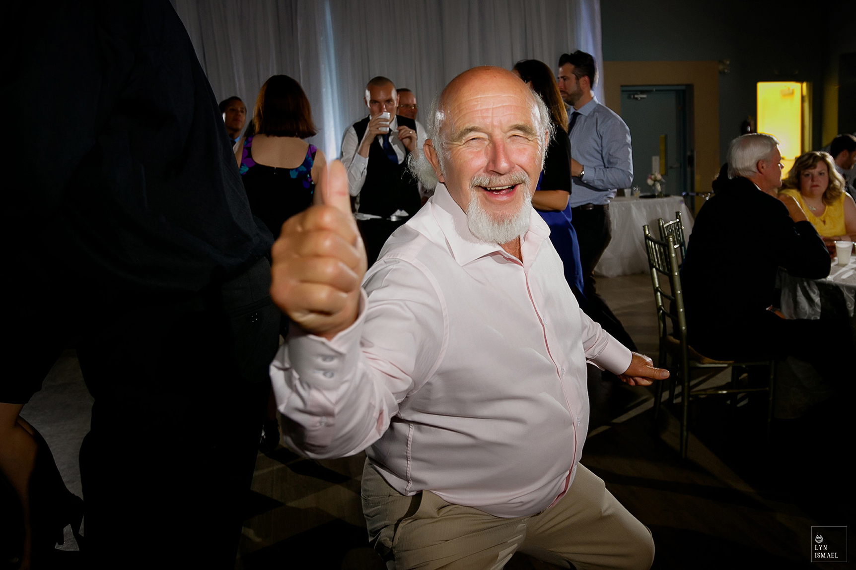 A man with a grey beard dances on the dance floor at a wedding reception in The Lakeview by Carmen's