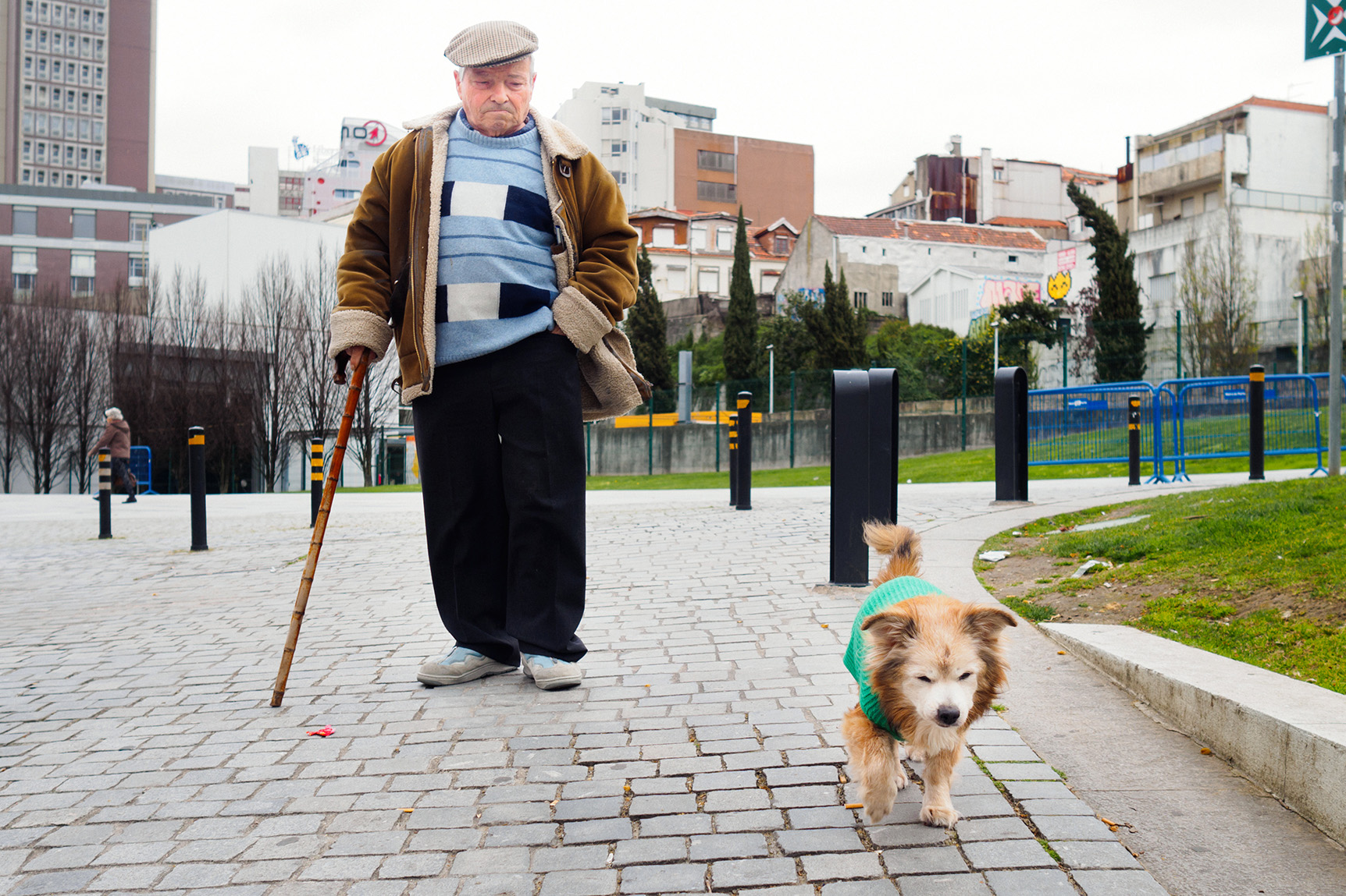 Old man walking with his old dog close to Trindade train station in Porto