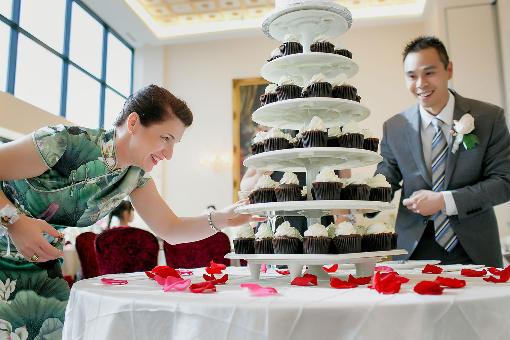 Bride and groom's friends decorate their cake stand