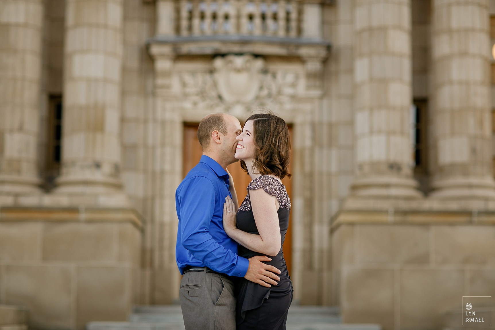 couple poses for their engagement session in front of Sunlife Financial Building in Waterloo