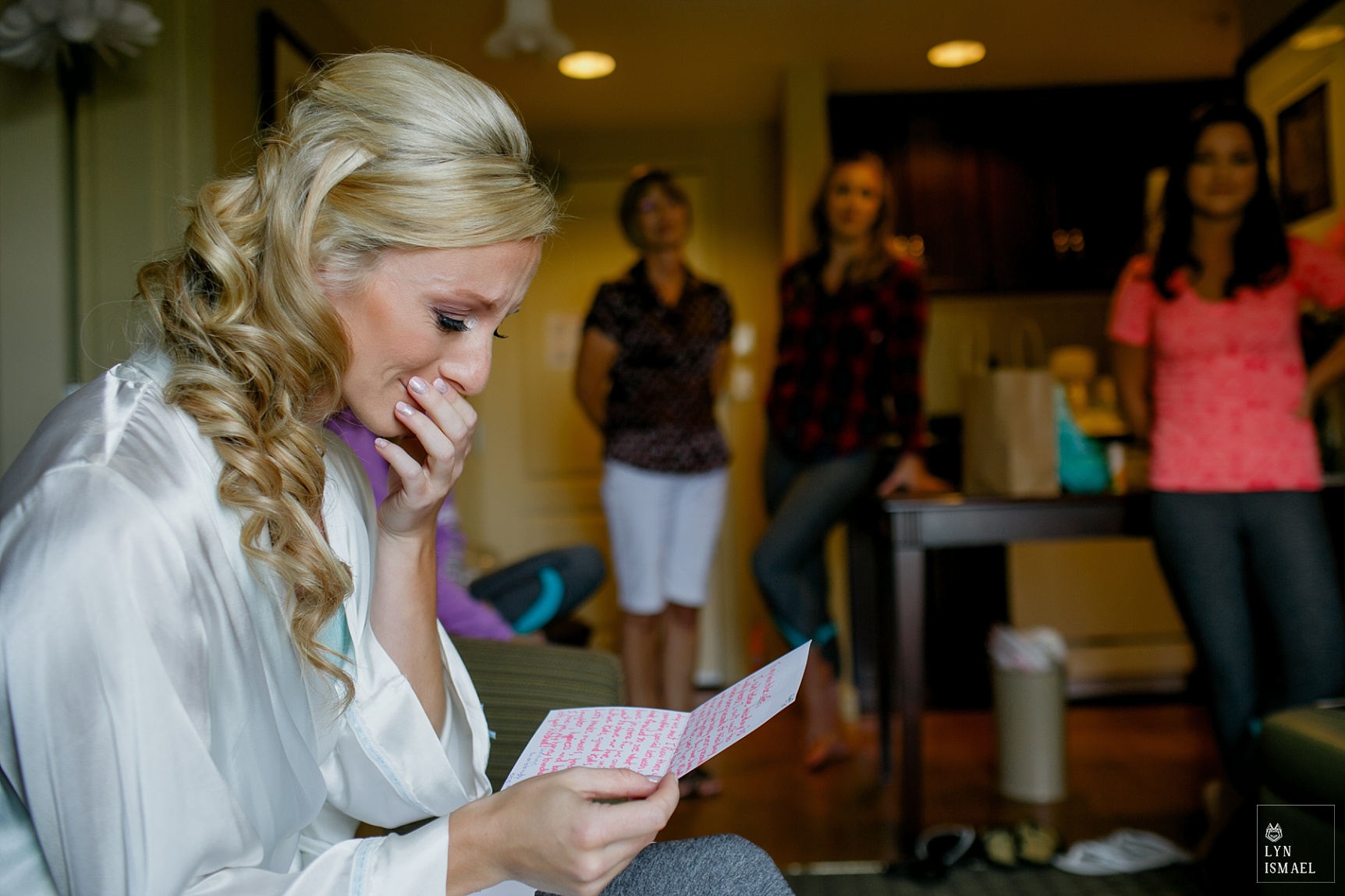 Bride reacts to her groom's letter as her bridesmaids watch on.