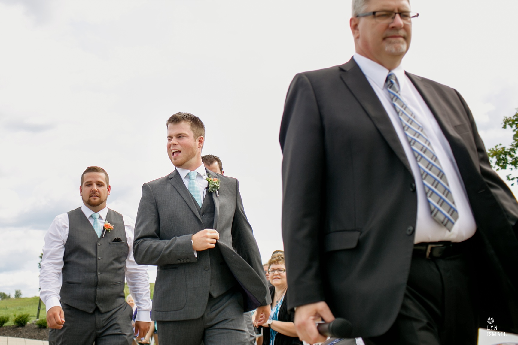 Groom walks down the aisle and winks at one of his guests