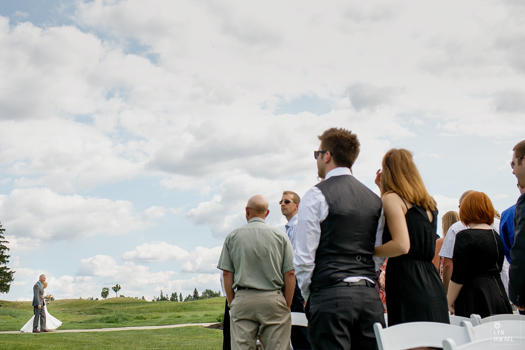 Bride walks down the aisle at Whistle Bear golf course with her father at her side.